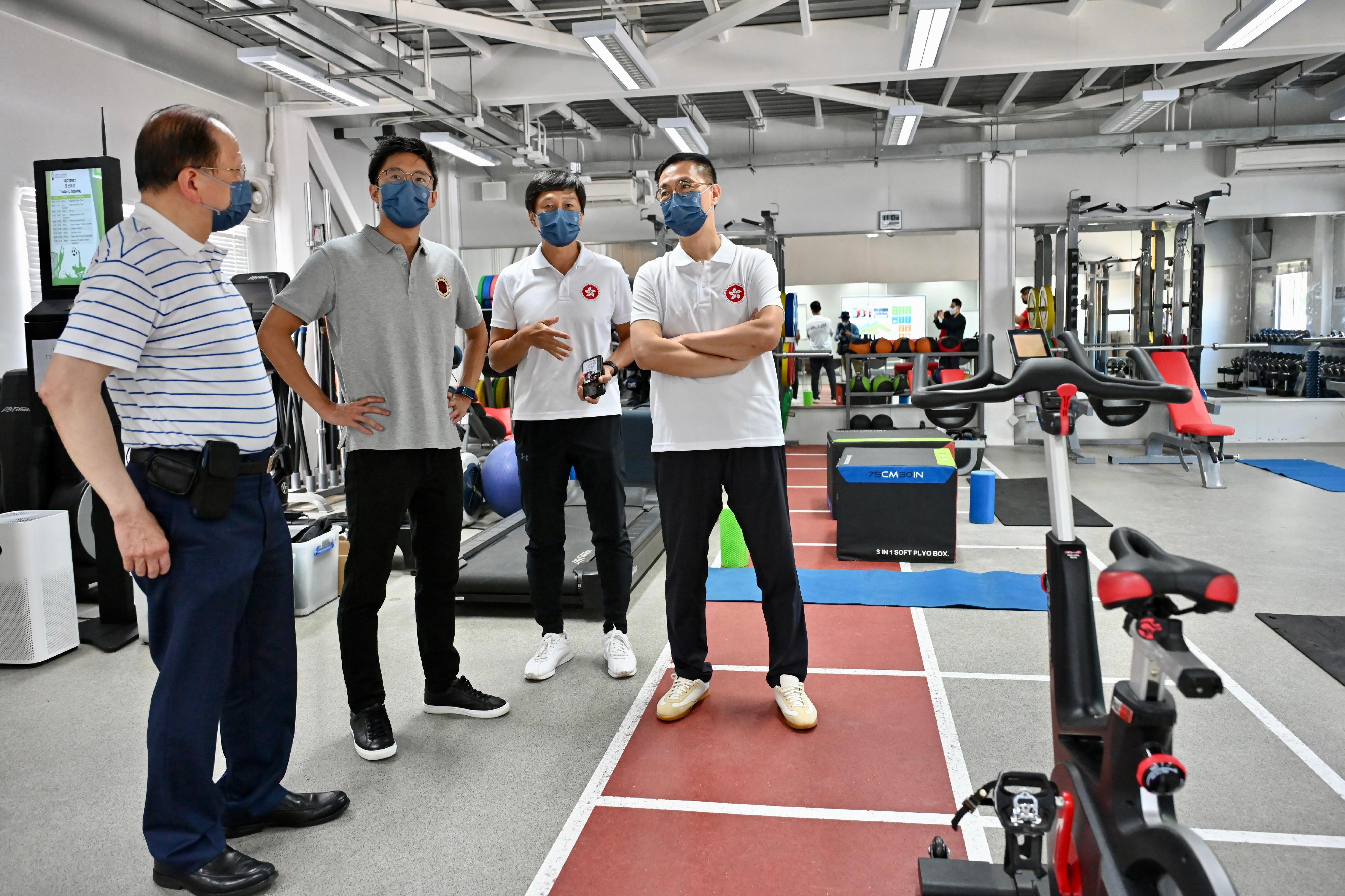 文化體育及旅遊局局長楊潤雄今日（七月十三日）到訪賽馬會香港足球總會足球訓練中心。圖示楊潤雄（右一）參觀健身房，了解香港足球代表隊的訓練情況。