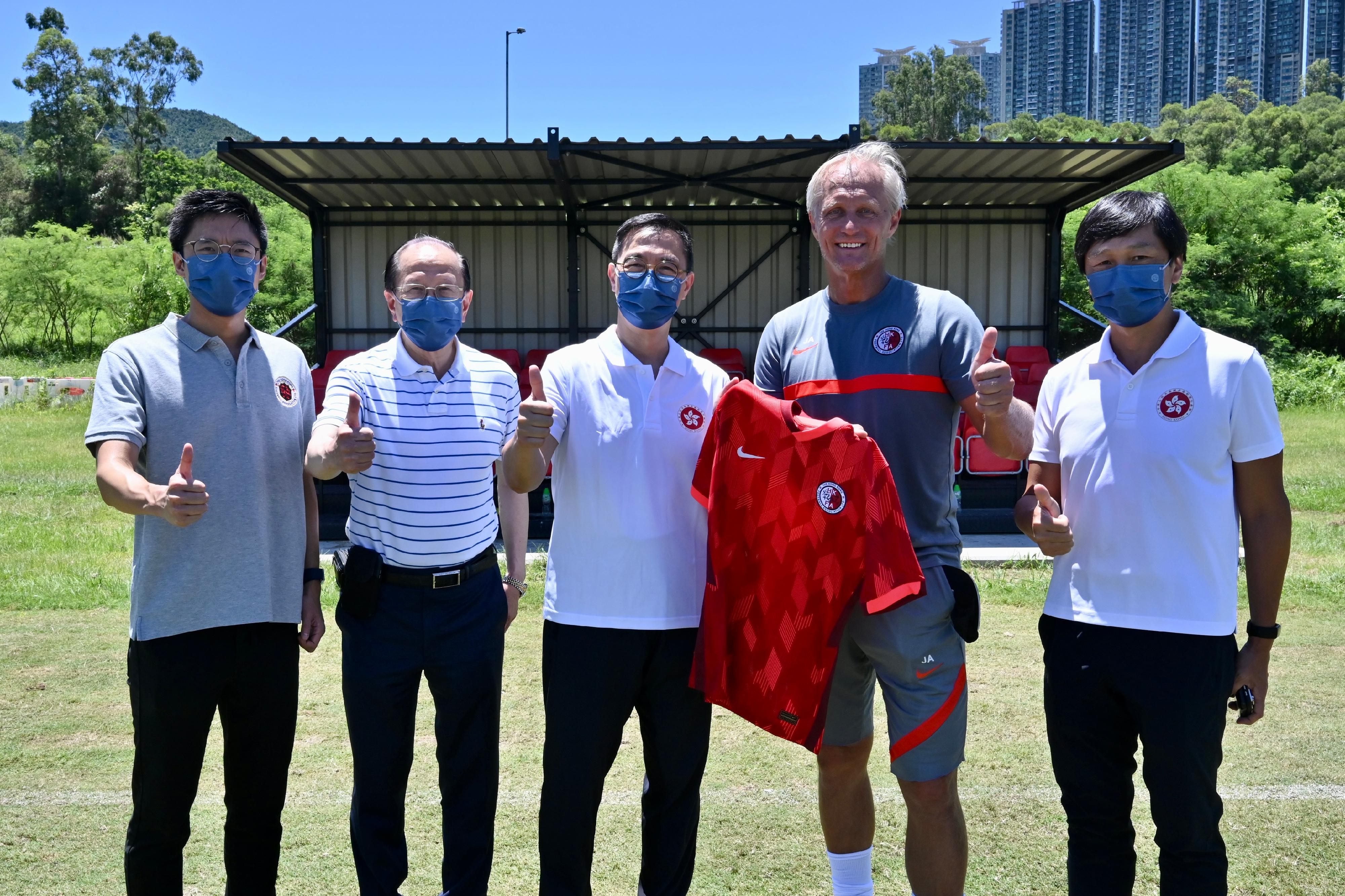 文化體育及旅遊局局長楊潤雄今日（七月十三日）到訪賽馬會香港足球總會足球訓練中心。圖示香港足球代表隊主教練安達臣（右二）向楊潤雄（中）致送紀念球衣。