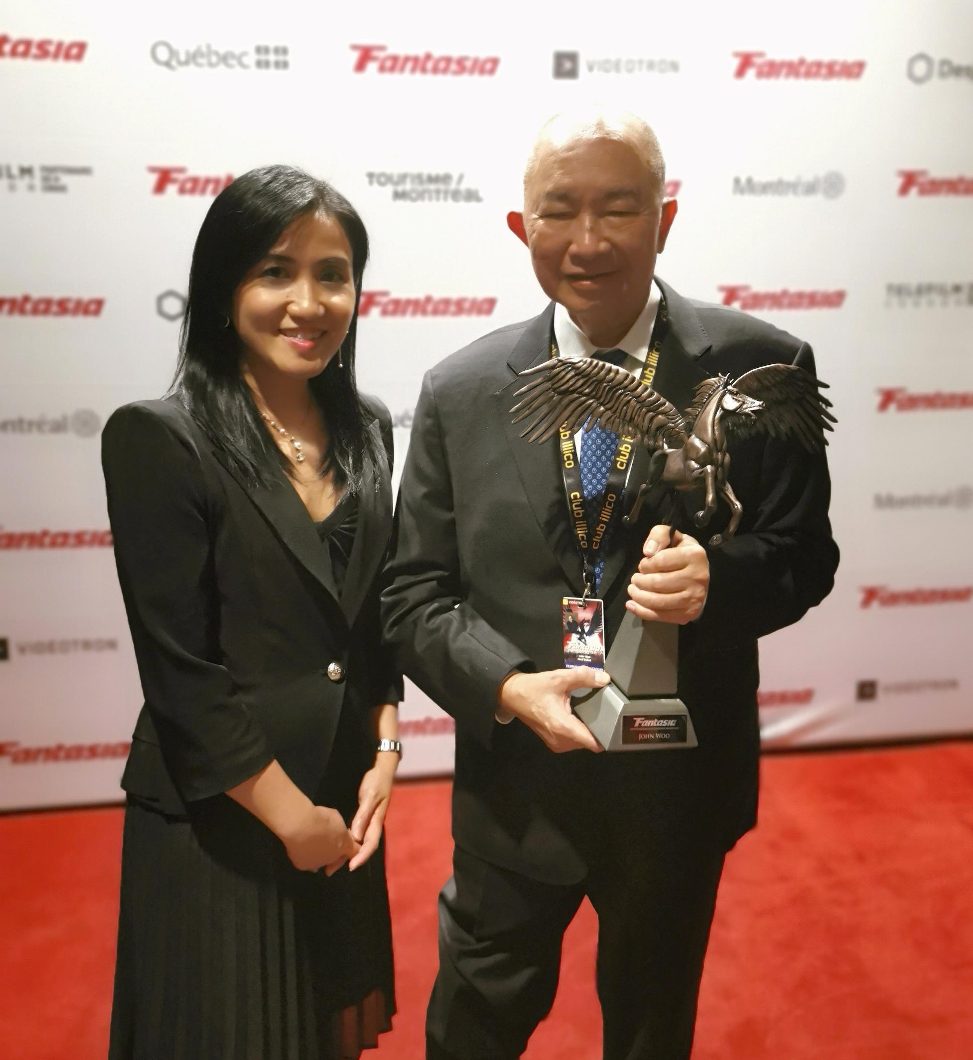 The Hong Kong Economic and Trade Office (Toronto) (Toronto ETO) supported the screening of seven Hong Kong films at the 26th Fantasia International Film Festival held from July 14 to August 3 in Montreal, Canada. Photo shows the Director of the Toronto ETO, Ms Emily Mo and Hong Kong Director, Mr John Woo with the "Career Achievement Award" presented by Fantasia International Film Festival on July 15 (Montreal time).