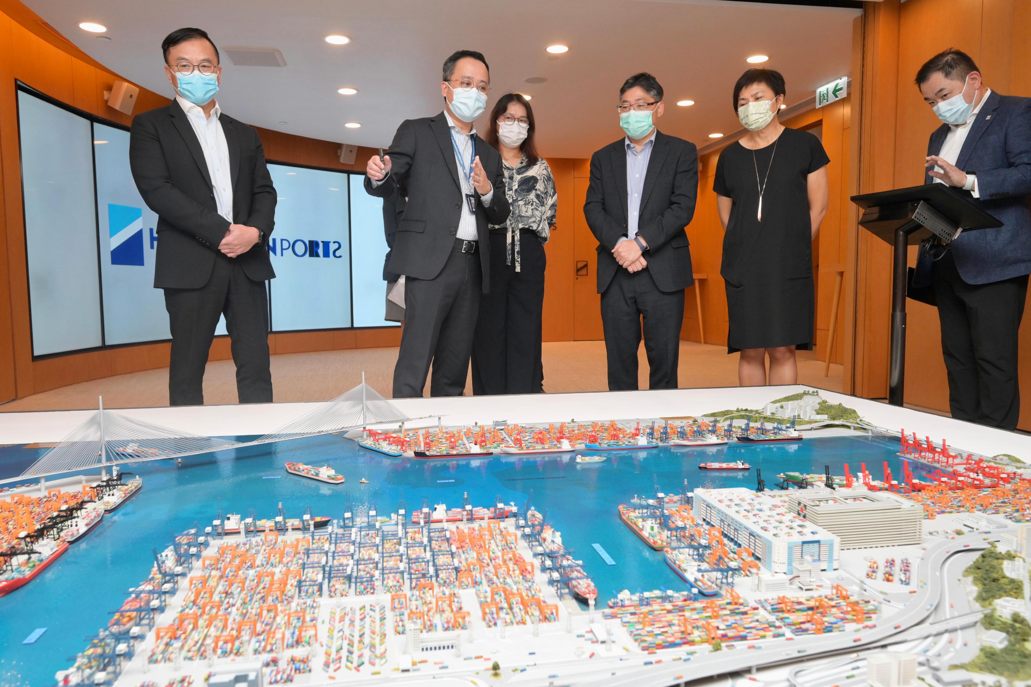 The Secretary for Transport and Logistics, Mr Lam Sai-hung, visited the Kwai Tsing Container Terminals (KTCT) today (July 19). Photo shows Mr Lam (third right), accompanied by the Chairman of the Hong Kong Container Terminal Operators Association, Ms Jessie Chung (second right), being briefed by the representatives of the operators of the KTCT on the operation of the terminals.