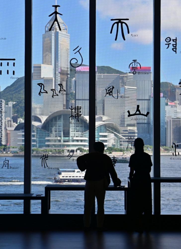 香港艺术馆明日（七月二十二日）起举行「汉字城韵──书法中的诗舞画乐」展览。图示展厅外玻璃窗贴上不同书体的汉字，把维港景色化身成文字的风景。