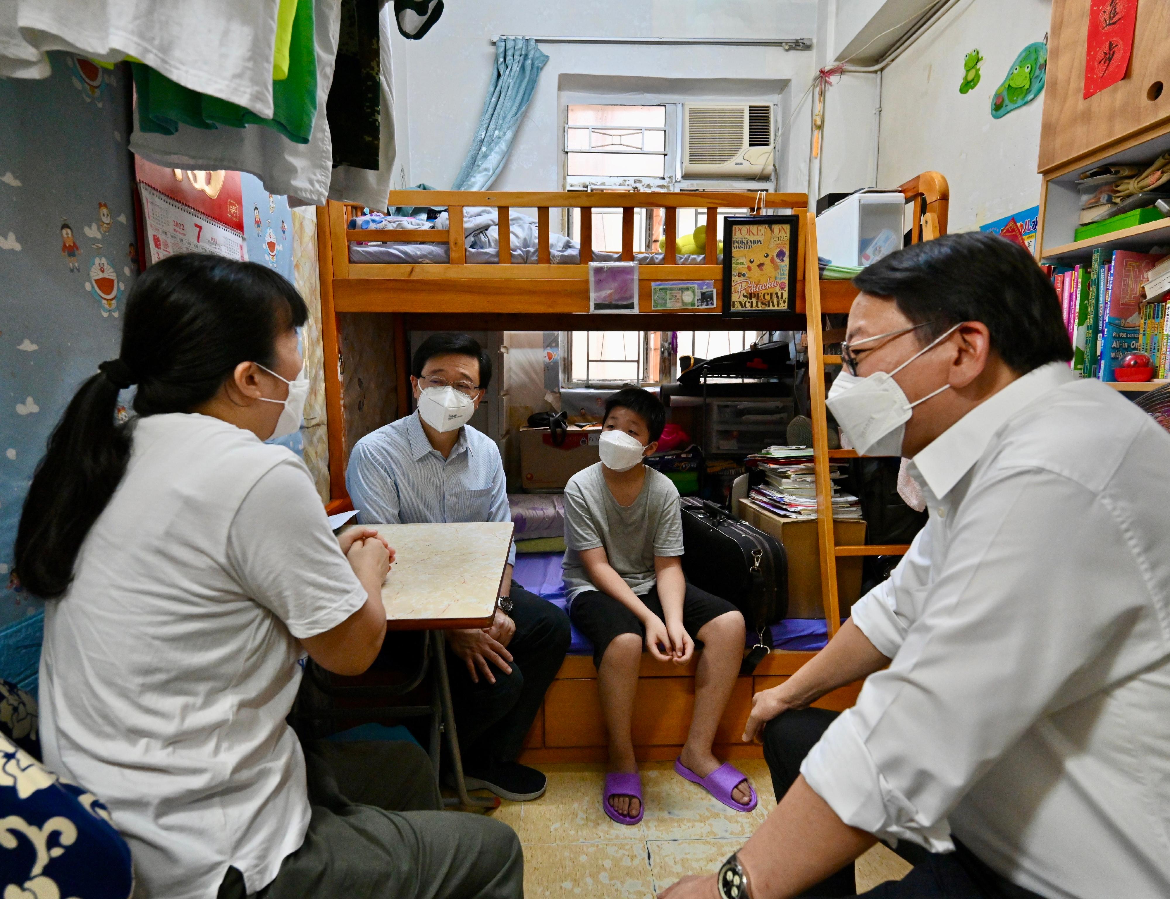 The Chief Executive, Mr John Lee, visited Sham Shui Po District today (July 30). Photo shows Mr Lee (second right), accompanied by the Chief Secretary for Administration, Mr Chan Kwok-ki (first right), visiting a grassroots family living in a subdivided unit to understand their living conditions.