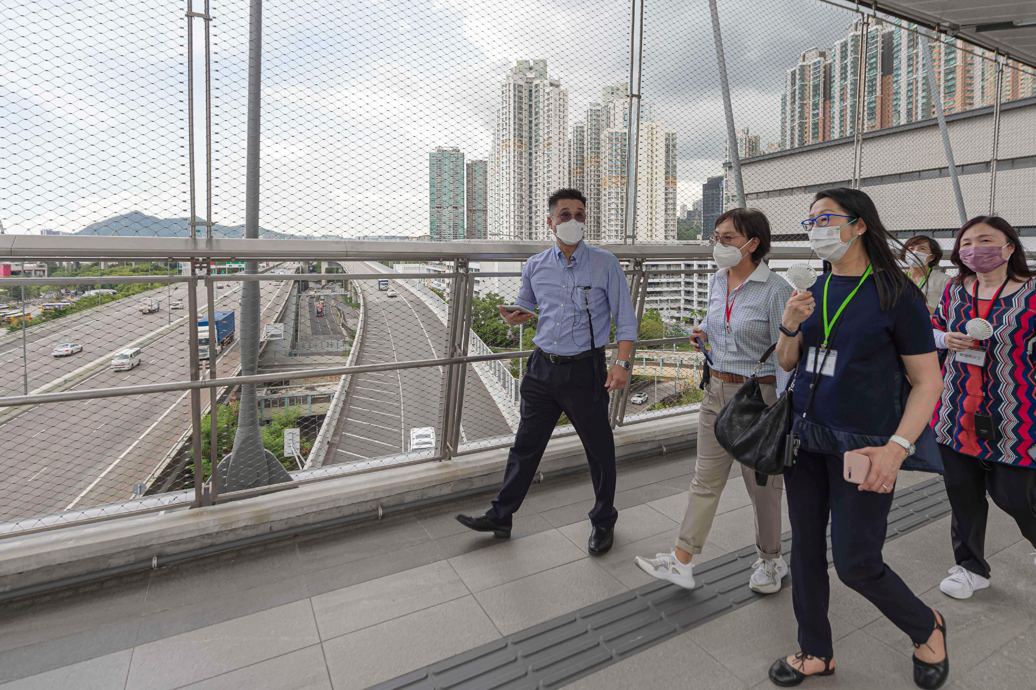 Members of the Hong Kong Housing Authority (HA) and its Commercial Properties Committee (CPC) today (August 2) visited the HA's non-domestic facilities. Photo shows a Housing Department official briefing the Chairman of the HA's CPC, Ms Serena Lau (second left), and the members of HA/CPC on the long span footbridge at Hoi Tat Estate in Sham Shui Po. 