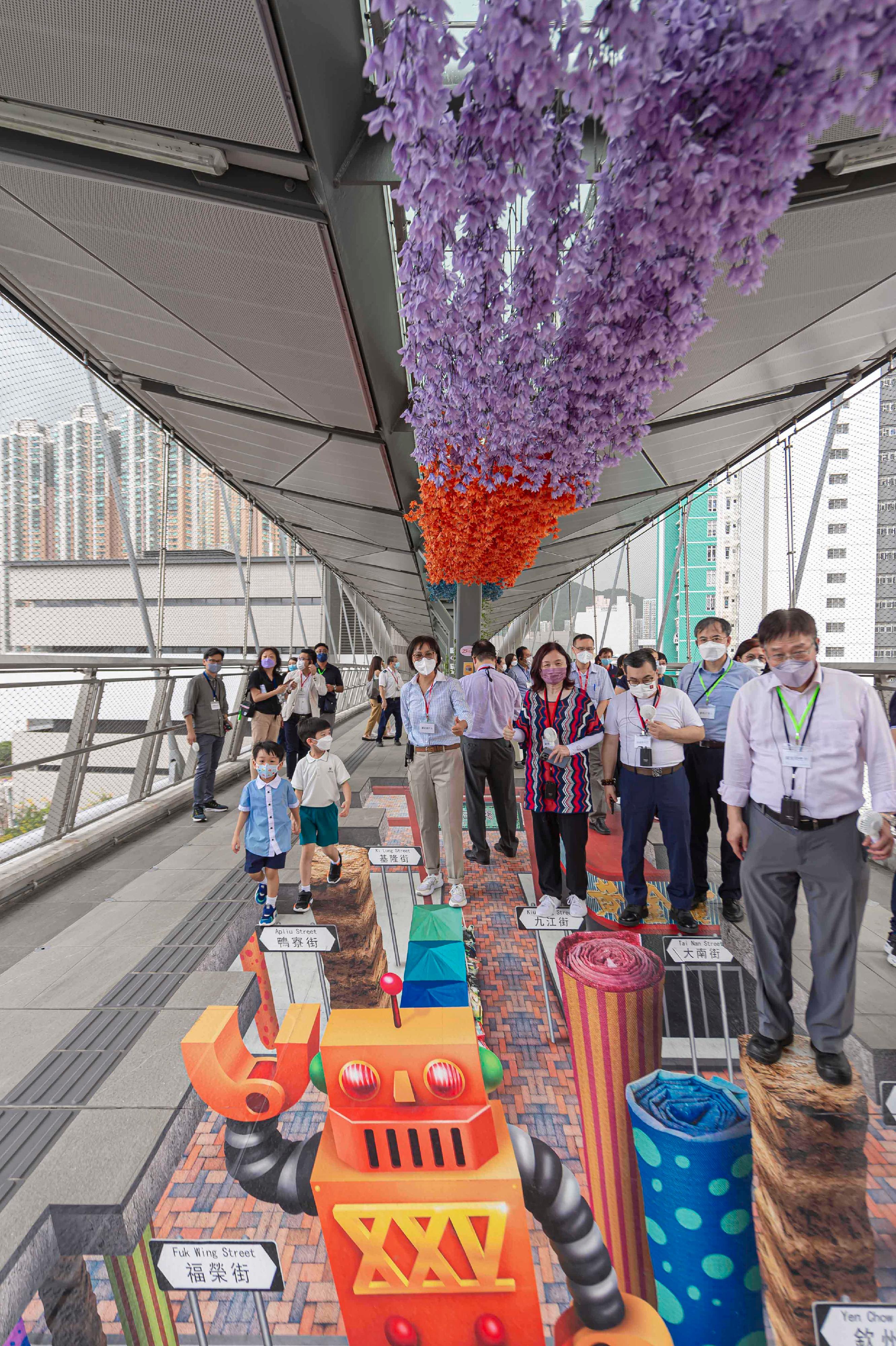Members of the Hong Kong Housing Authority (HA) and its Commercial Properties Committee (CPC) today (August 2) visited the HA's non-domestic facilities. Photo shows the Chairman of the HA's CPC, Ms Serena Lau (front row, third left), and the members of HA/CPC viewing a 3D painting on the long span footbridge at Hoi Tat Estate in Sham Shui Po.
