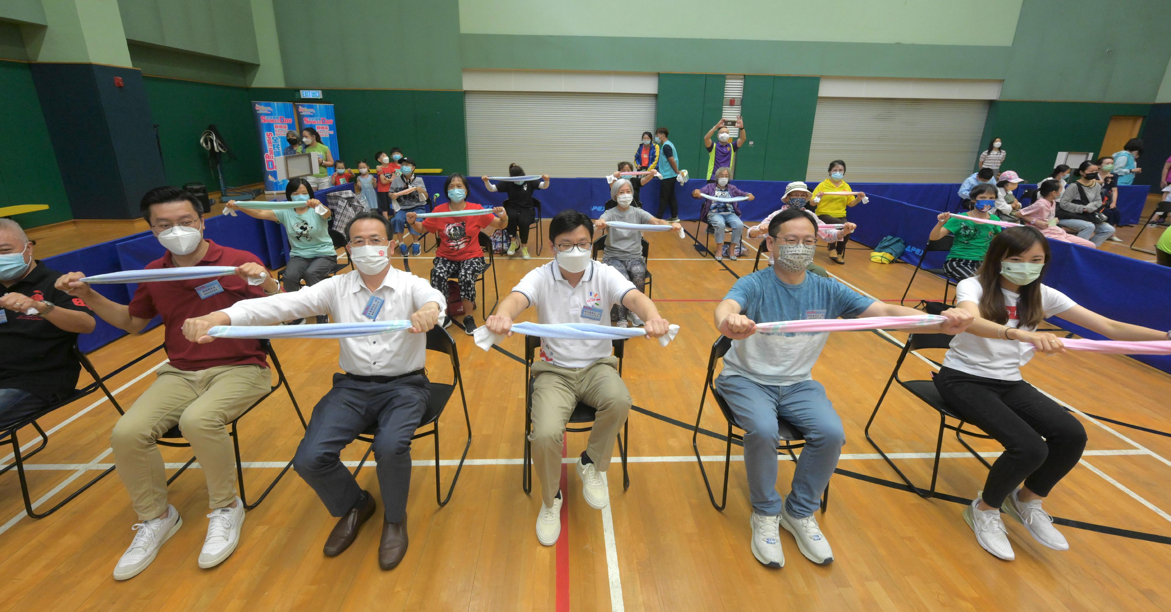 The Secretary for Labour and Welfare, Mr Chris Sun, joined the public for sports and recreation programmes at Lei Yue Mun Sports Centre this afternoon (August 7) as part of Sport For All Day 2022 organised by the Leisure and Cultural Services Department. Photo shows Mr Sun (front row, centre), accompanied by the Chairman of Kwun Tong District Council, Mr Wilson Or (front row, second right), and the Acting District Officer (Kwun Tong), Miss Cherry Sum (front row, first right), doing towel fitness exercises training physical fitness.