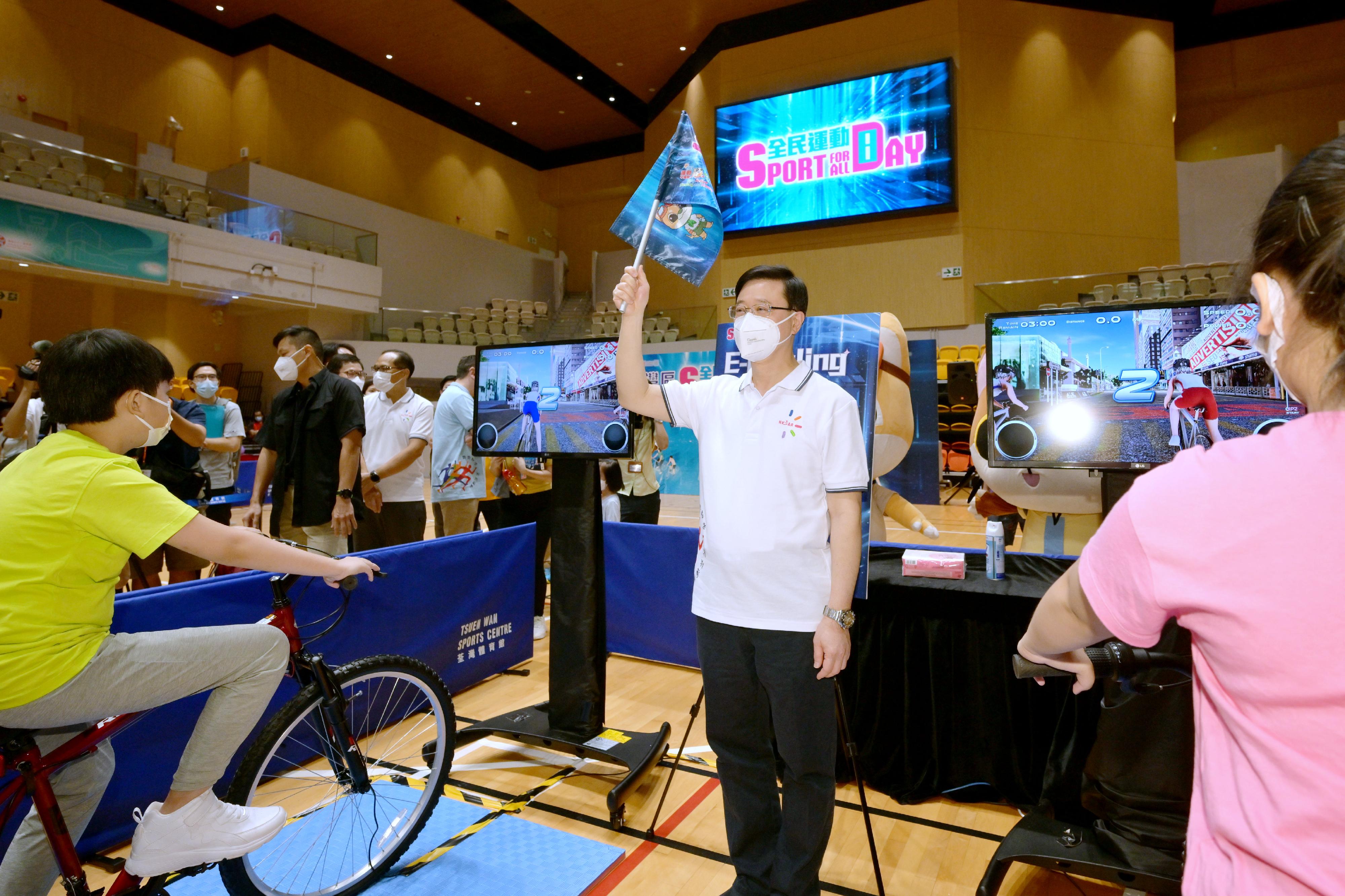 The Chief Executive, Mr John Lee, joined the public for sports and recreation programmes at Tsuen Wan Sports Centre this afternoon (August 7) as part of Sport For All Day 2022 organised by the Leisure and Cultural Services Department. Photo shows Mr Lee (centre) starting the electronic virtual cycling contest.
