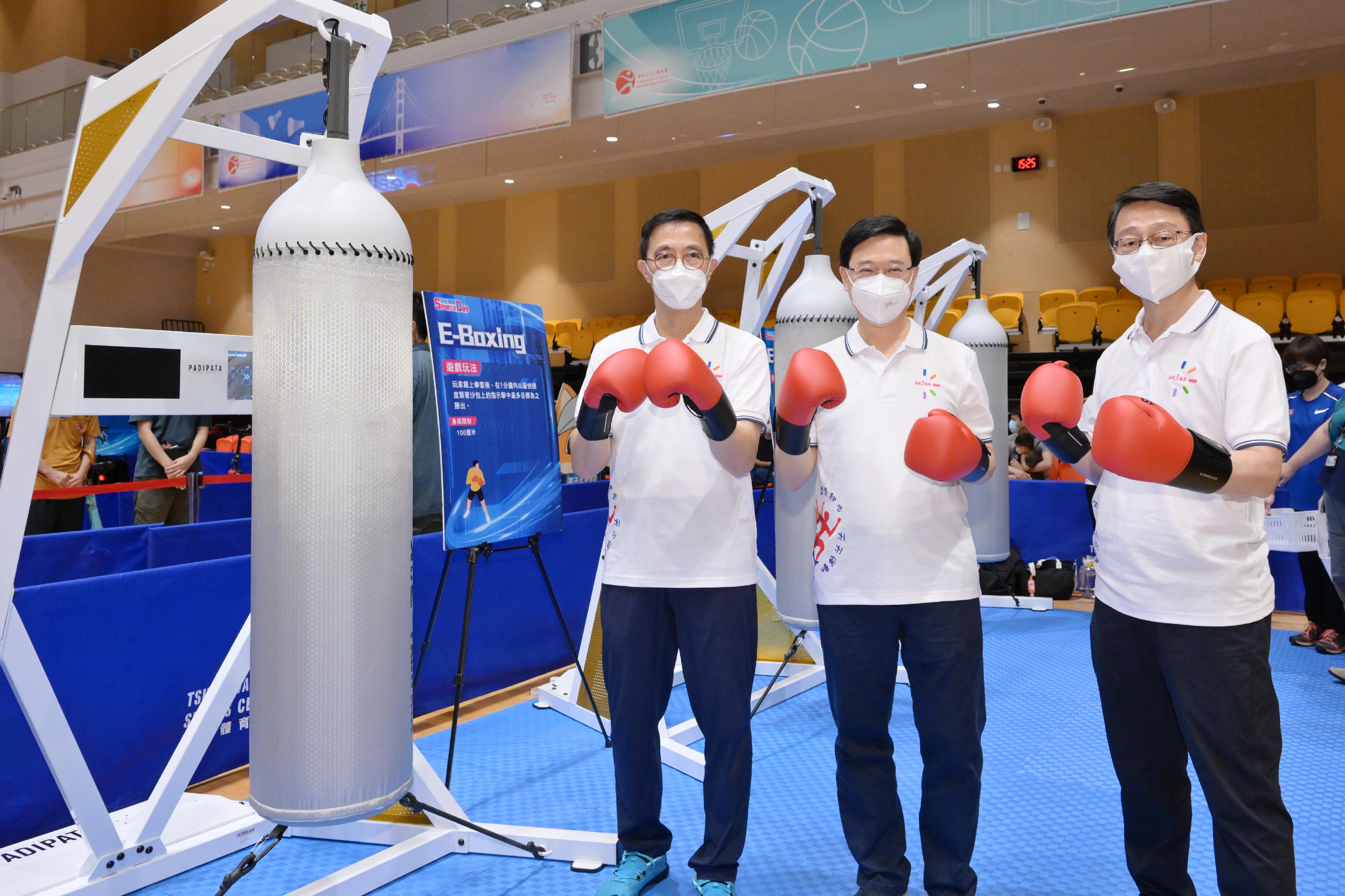 The Chief Executive, Mr John Lee, joined the public for sports and recreation programmes at Tsuen Wan Sports Centre this afternoon (August 7) as part of Sport For All Day 2022 organised by the Leisure and Cultural Services Department. Photo shows Mr Lee (centre); the Secretary for Culture, Sports and Tourism, Mr Kevin Yeung (left), and the Director of Leisure and Cultural Services, Mr Vincent Liu (right), taking part in an electronic virtual boxing exploration activity. 