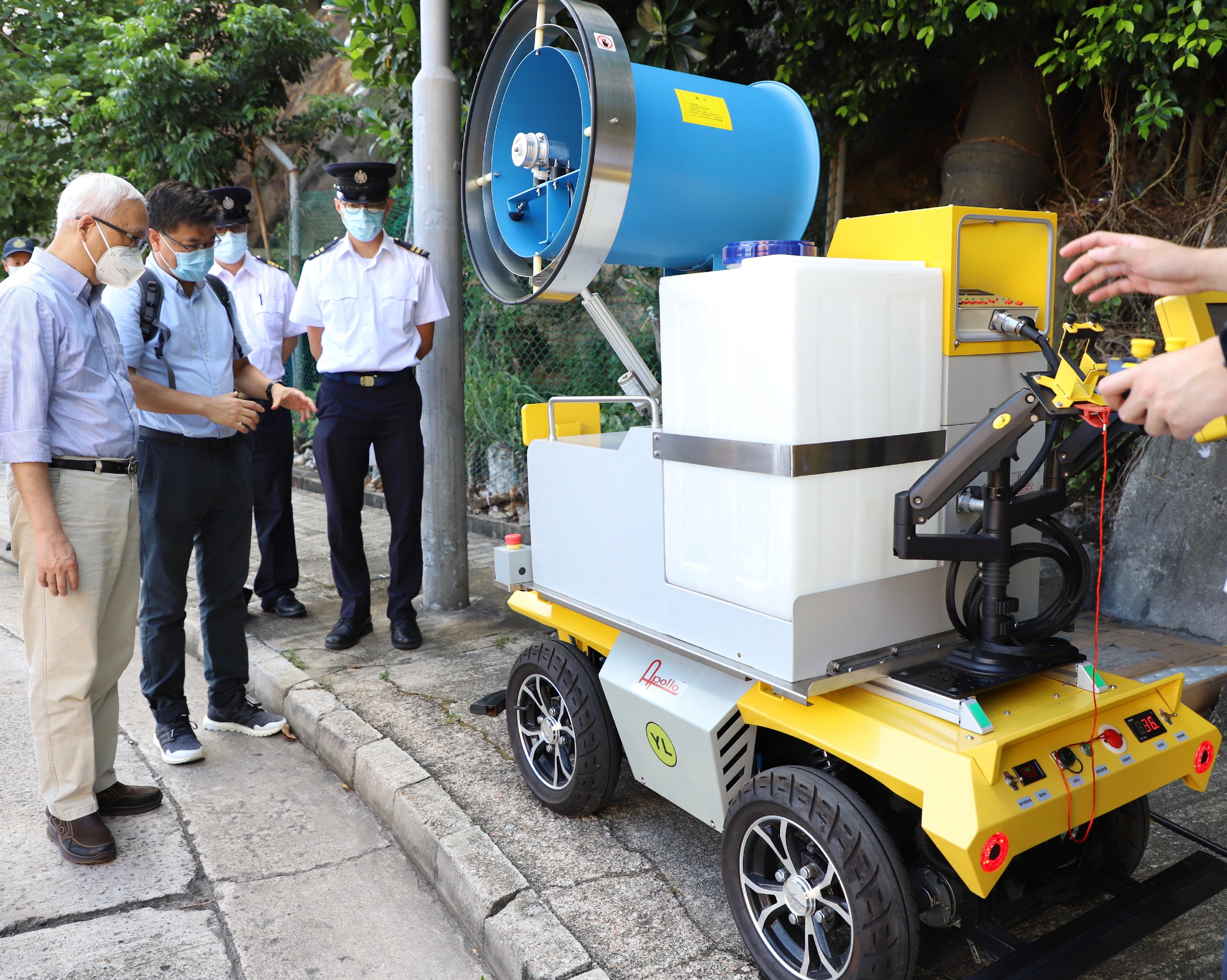 The Secretary for Environment and Ecology, Mr Tse Chin-wan, today (August 7) inspected the Food and Environmental Hygiene Department (FEHD)'s anti-mosquito measures at the hillside near Princess Margaret Hospital, Kwai Chung. Photo shows Mr Tse (left) being briefed on the operation of a large robotics ultra-low volume fogger for spraying pesticides. 