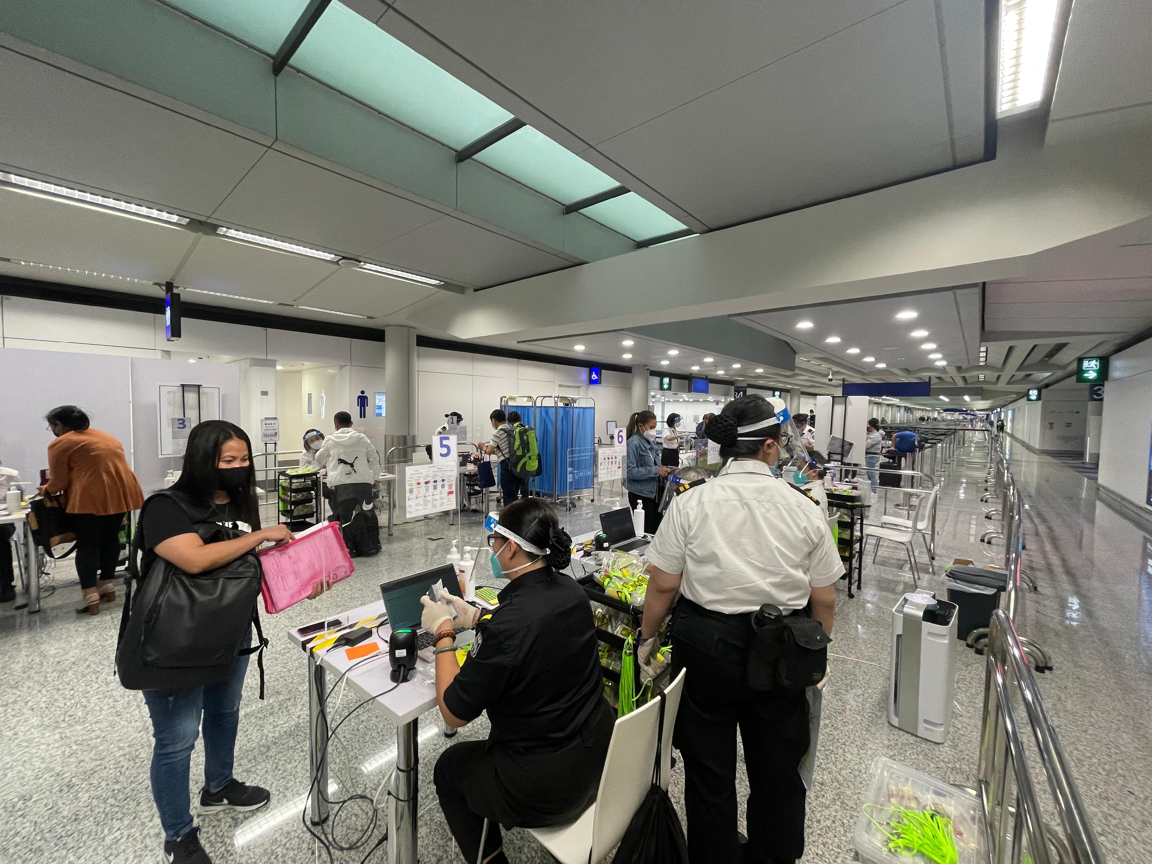 The Government implemented streamlined procedures of arrival quarantine and testing at the airport starting from today (August 12). Photo shows inbound persons registering for on-site specimen collection for nucleic acid and rapid antigen tests at the arrival level of Terminal 1.