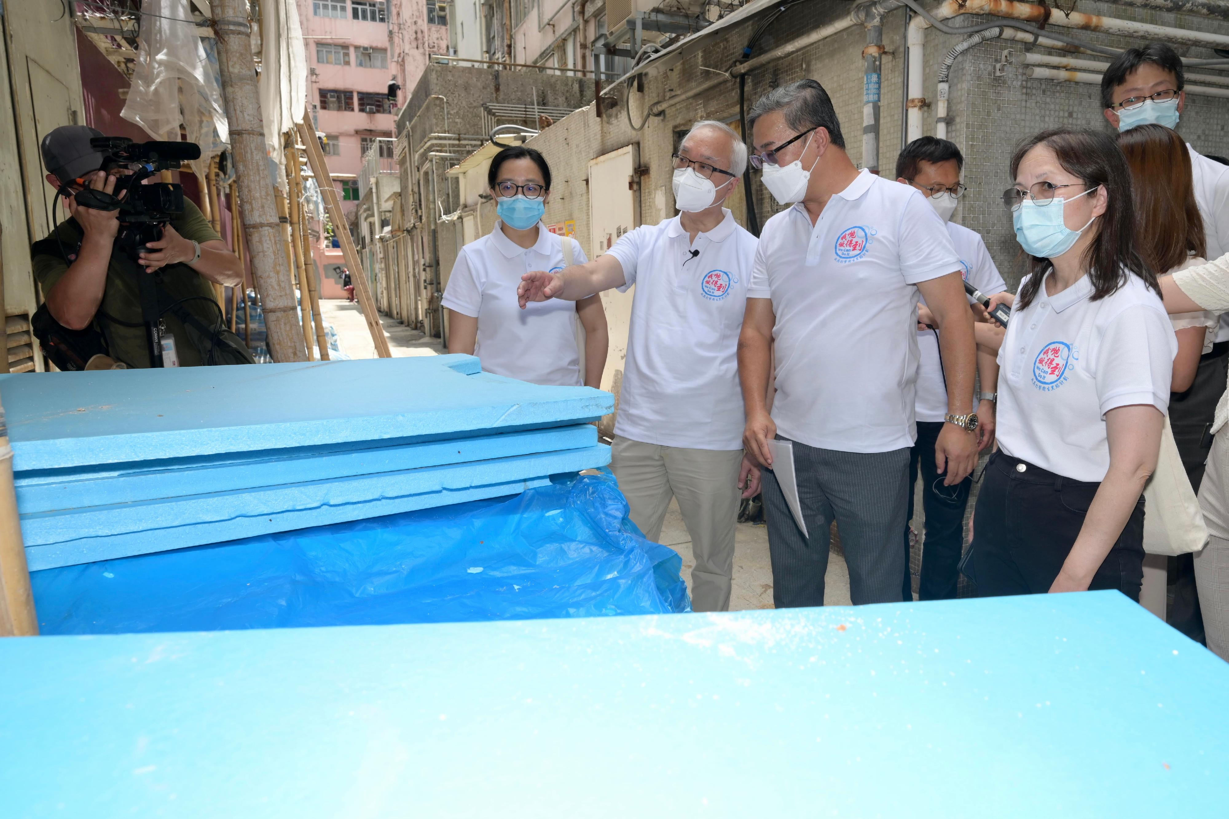 The Secretary for Environment and Ecology, Mr Tse Chin-wan (third left), accompanied by the Director of Food and Environmental Hygiene, Ms Irene Young (second left), inspected the clearance operation carried out by the Food and Environmental Hygiene Department (FEHD) against refuse and waste piled up in the rear lane of Shui Che Kwun Street in Yuen Long District today (August 14). Picture shows Mr Tse examining the FEHD's work for clearance of miscellaneous articles and rodent control in rear lane.