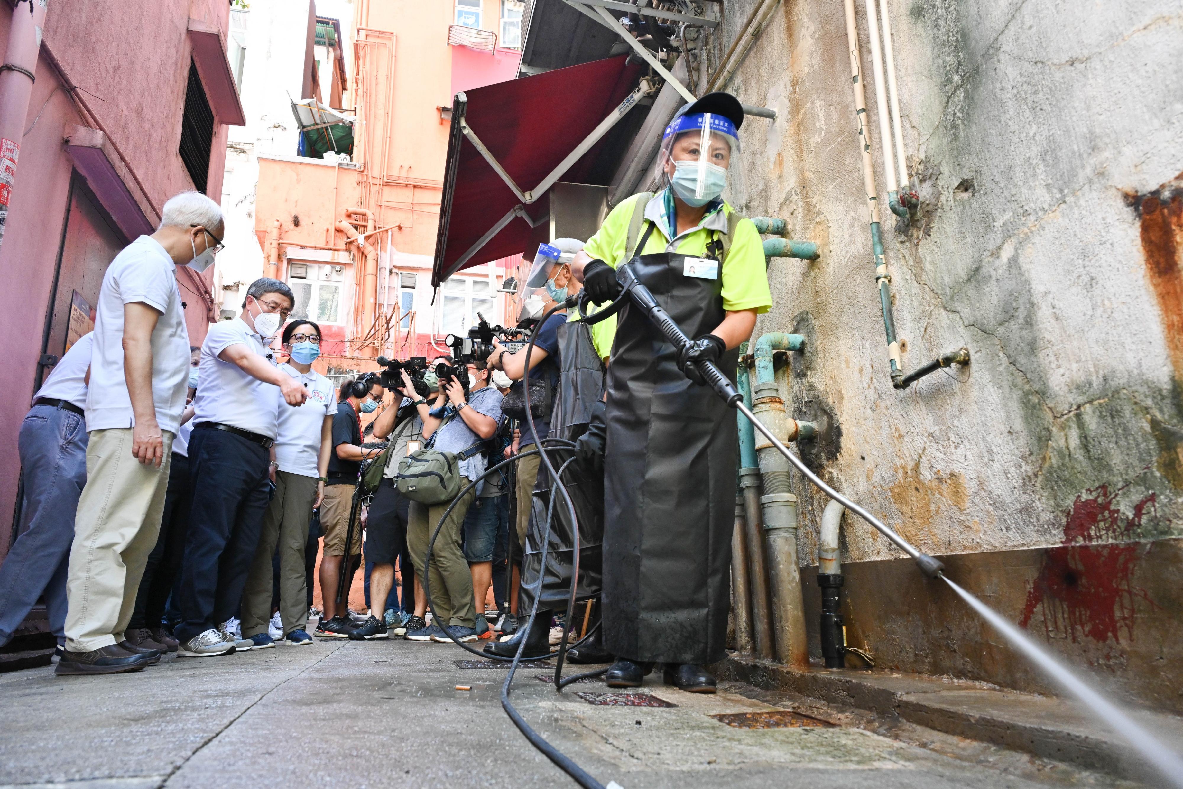 The Deputy Chief Secretary for Administration, Mr Cheuk Wing-hing, inspected hygiene black spot in Lai Chi Kok Road today (August 14). Photo shows Mr Cheuk (second left), looking on as staff members conduct street cleaning by high-pressure water jet at a hygiene black spot. Also present is the Secretary for Environment and Ecology, Mr Tse Chin-wan (first left).
