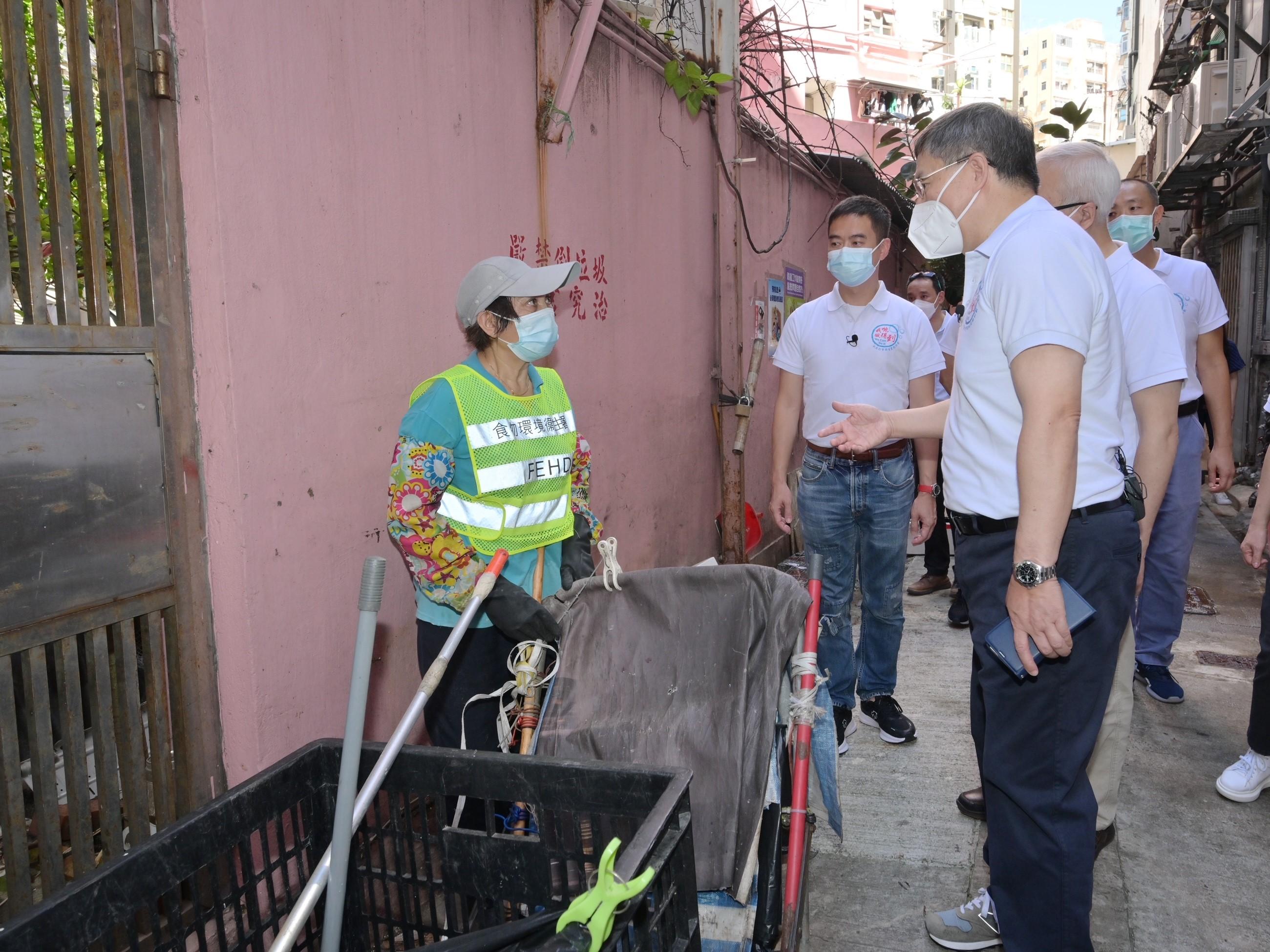 The Deputy Chief Secretary for Administration, Mr Cheuk Wing-hing, inspected hygiene black spot in Lai Chi Kok Road today (August 14) to view operations carried out by departments to clear trash and miscellaneous articles. Photo shows Mr Cheuk (first right), chatting with a staff member to understand her working condition.
