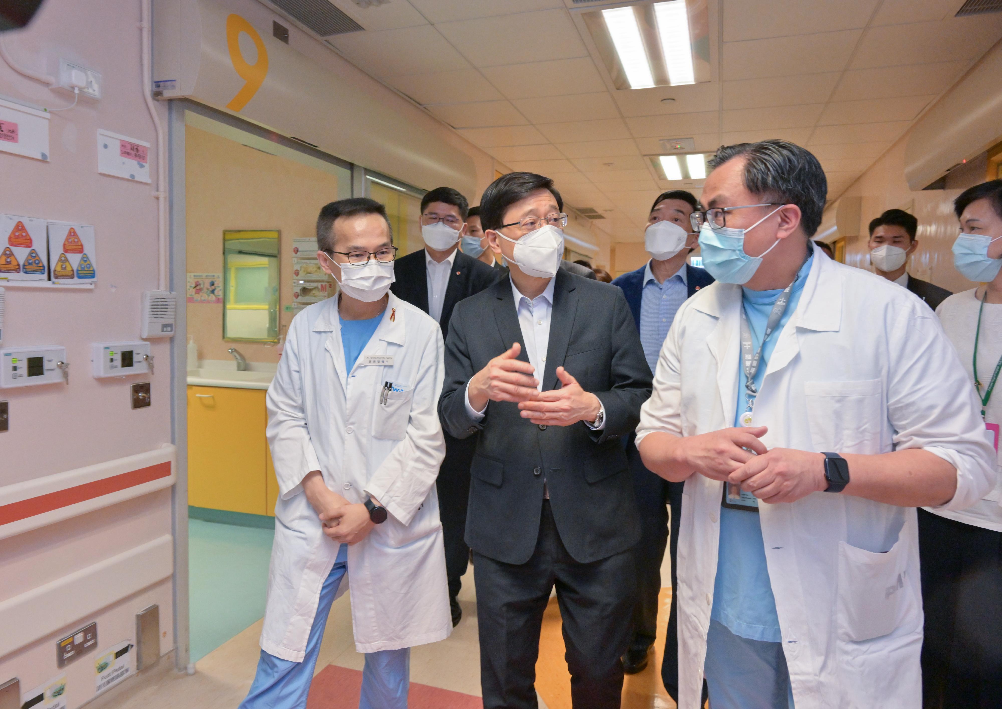 The Chief Executive, Mr John Lee (front row, centre), today (August 17) inspects the Hospital Authority Infectious Disease Centre and receives a briefing from medical professionals on the operation of Paediatric Isolation Wards.