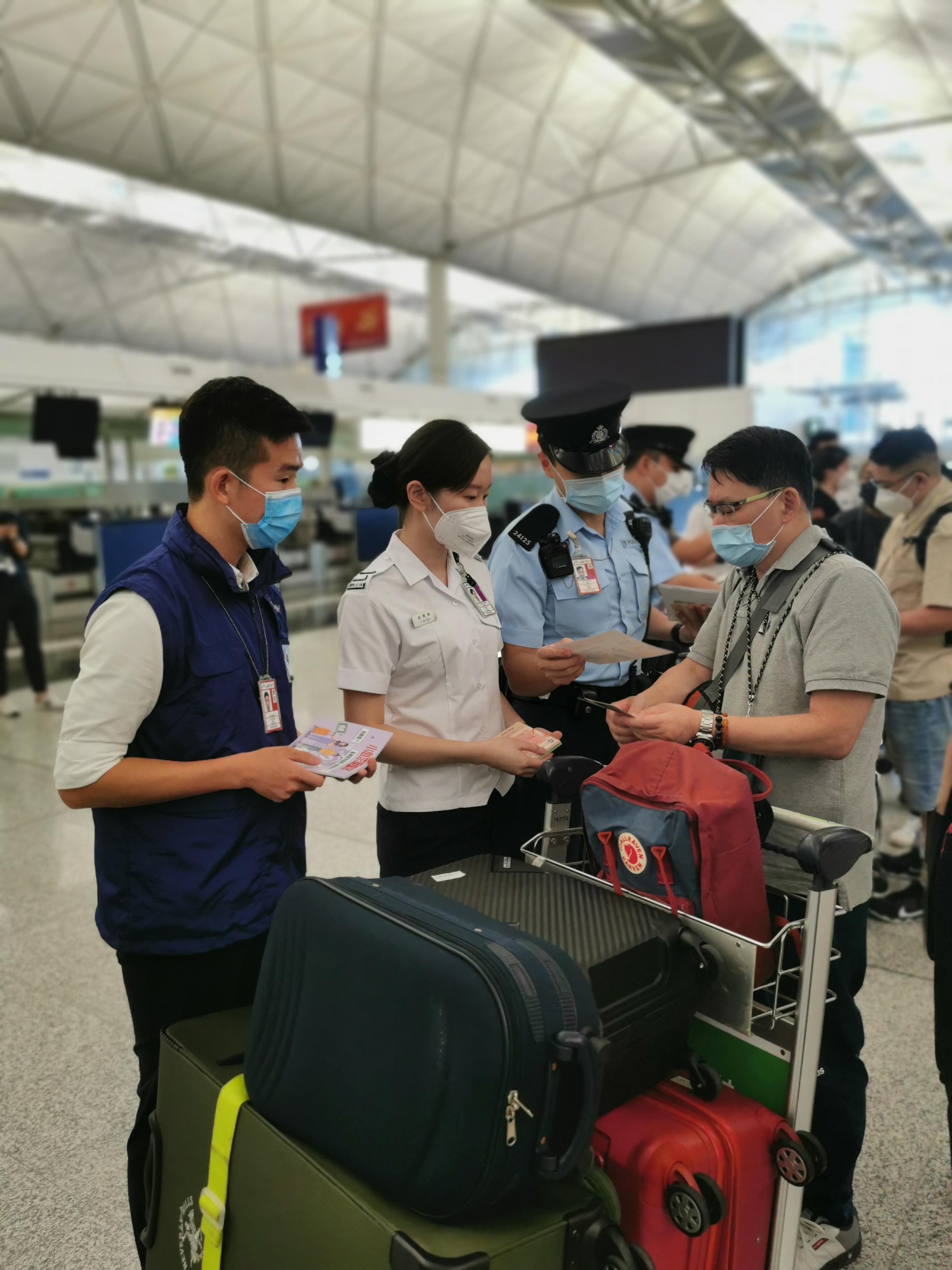 警務處和入境事務處人員今日（八月十八日）在香港國際機場預辦登機櫃位派發宣傳單張，提醒離港旅客小心求職騙案及注意外遊安全。