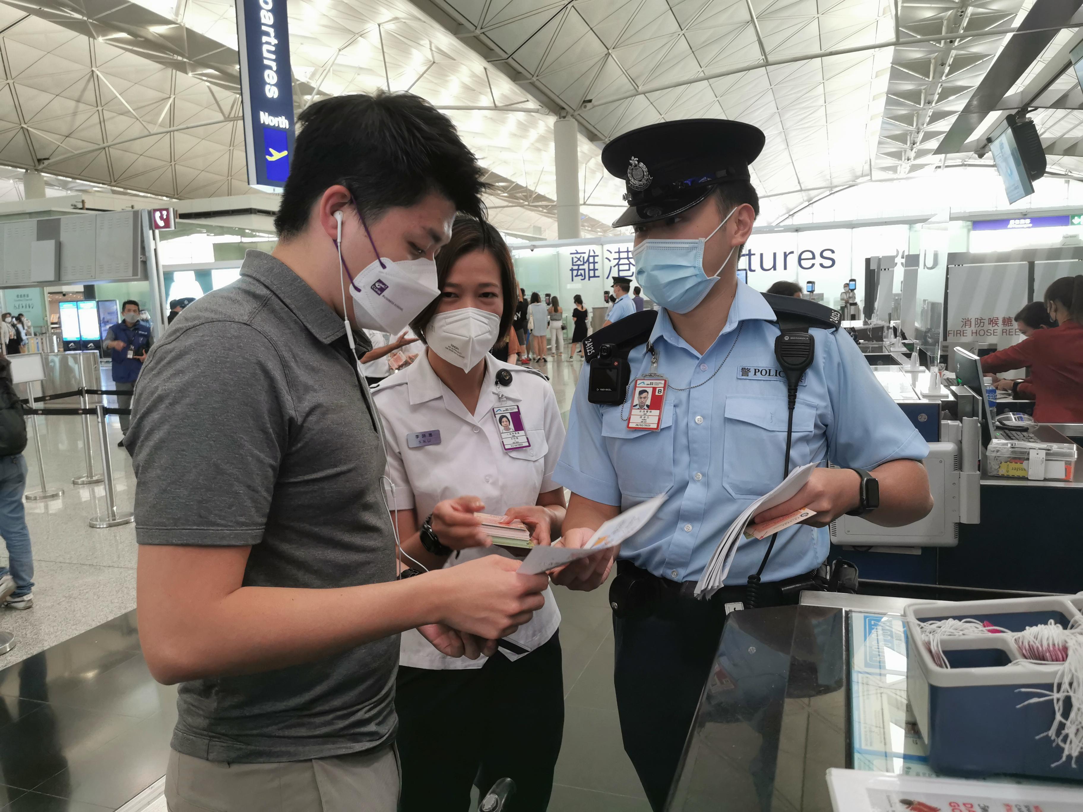 警務處和入境事務處人員今日（八月十八日）在香港國際機場預辦登機櫃位派發宣傳單張，提醒離港旅客小心求職騙案及注意外遊安全。