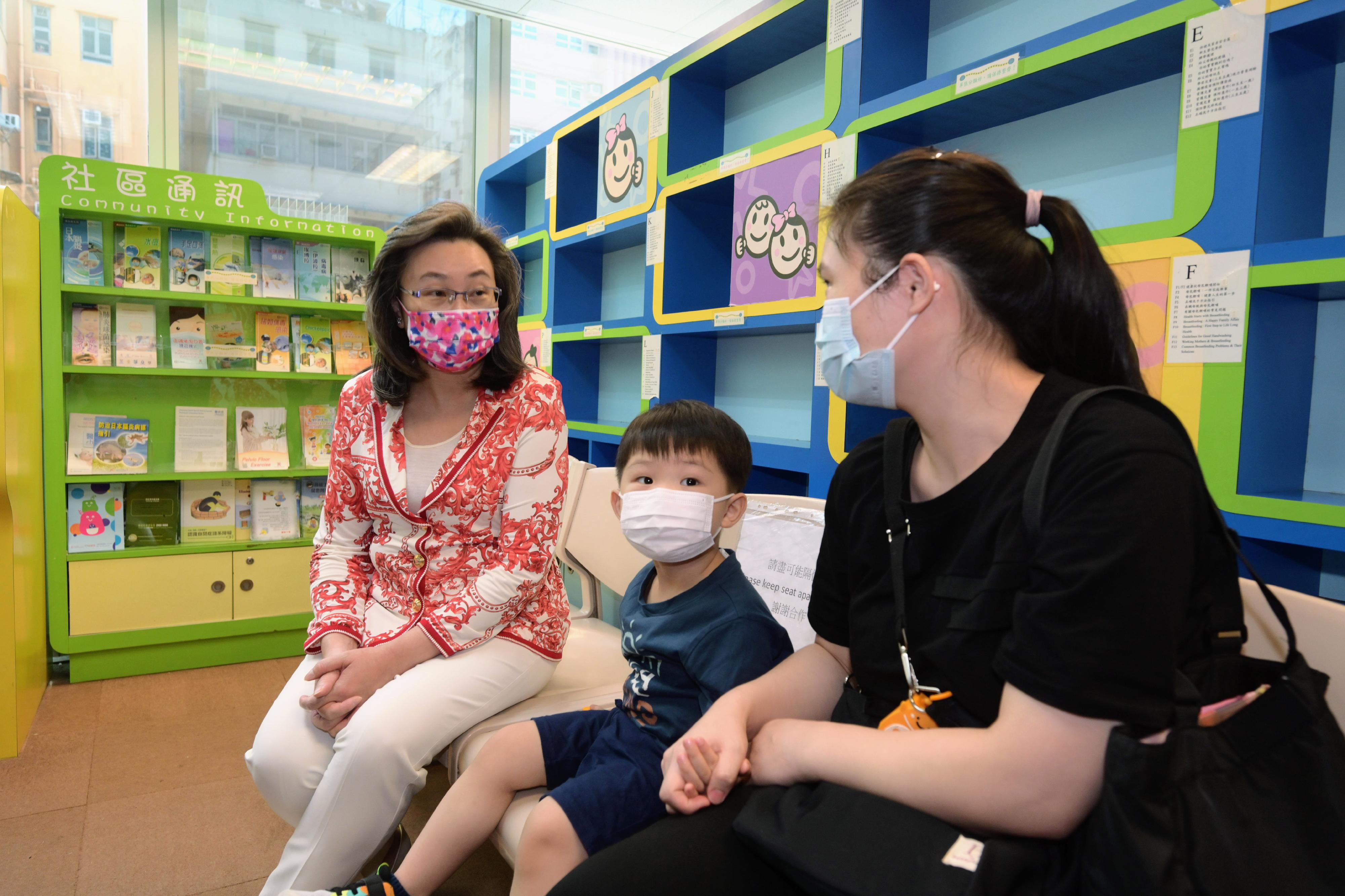 The Secretary for the Civil Service, Mrs Ingrid Yeung, today (August 23) visited West Kowloon Maternal and Child Health Centre to learn about the arrangements of providing a COVID-19 vaccination service for children there. Photo shows Mrs Yeung (first left) chatting with the parent of a young child to hear her views on COVID-19 vaccination for young children.