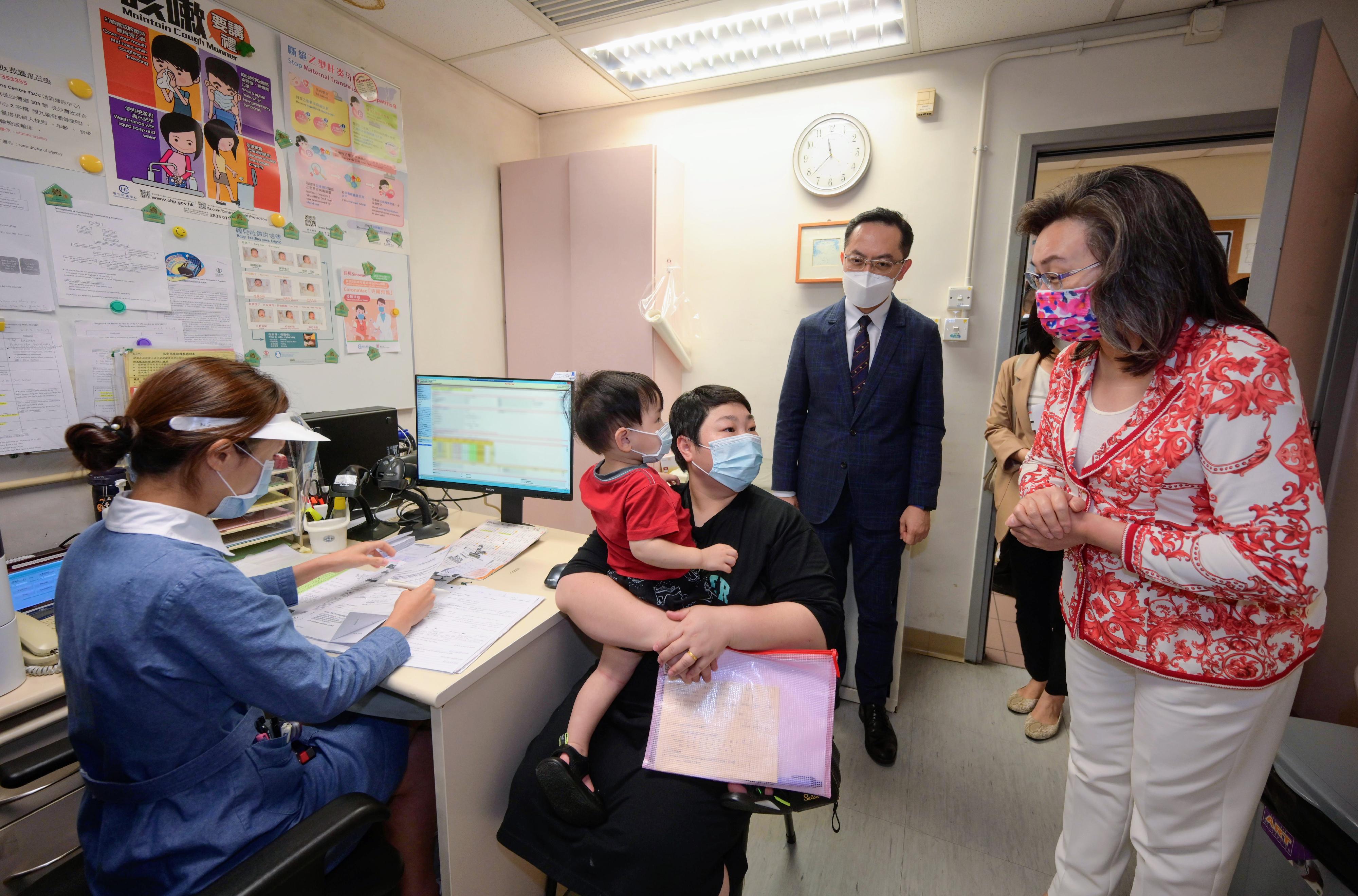 The Secretary for the Civil Service, Mrs Ingrid Yeung, today (August 23) visited West Kowloon Maternal and Child Health Centre to learn about the arrangements of providing a COVID-19 vaccination service for children there. Photo shows Mrs Yeung (first right) introducing the vaccination service to the parent of a 17-month-old boy. Looking on is the Director of Health, Dr Ronald Lam (second right).