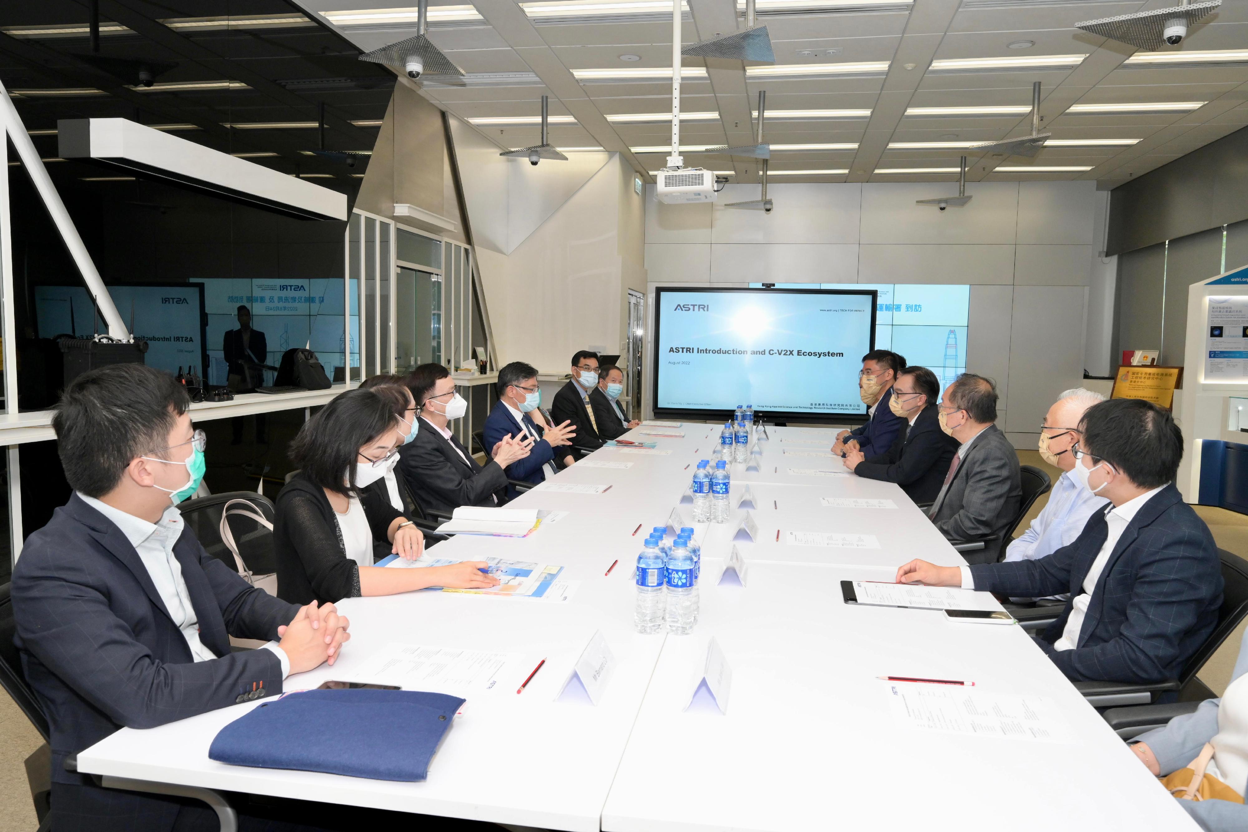The Secretary for Transport and Logistics, Mr Lam Sai-hung, visited the Hong Kong Applied Science and Technology Research Institute Company Limited (ASTRI) at the Hong Kong Science Park today (August 24). Photo shows Mr Lam (fifth left), and the Under Secretary for Transport and Logistics, Mr Liu Chun-san (fourth left), receiving a briefing from ASTRI representatives on their research progress and achievements of C-V2X technology since 2016.
