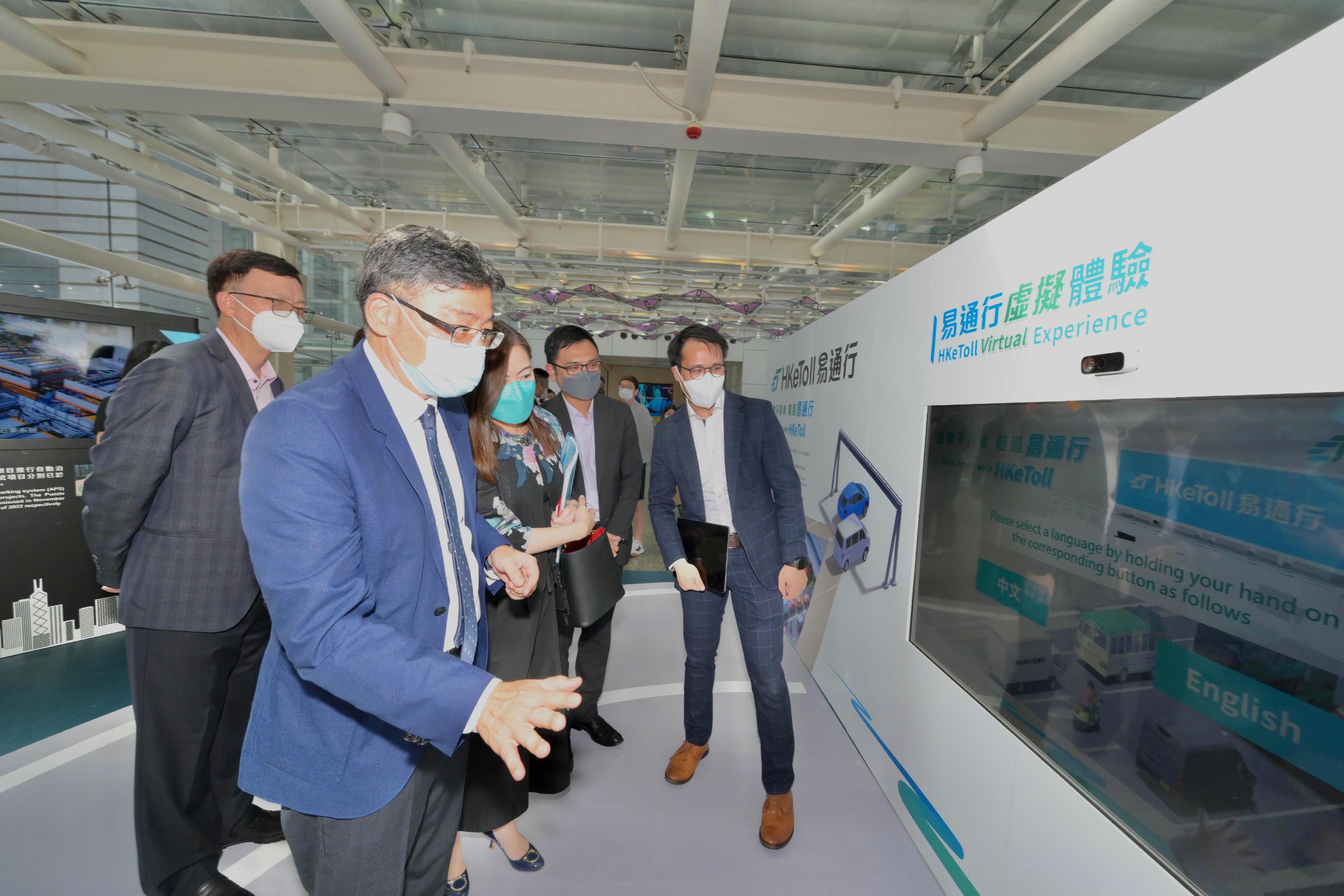 The Secretary for Transport and Logistics, Mr Lam Sai-hung, toured the "Journey Smart" roving exhibition held by the Transport Department at the Hong Kong Science Park. Photo shows Mr Lam (second left) trying out an interactive game which showcases the "HKeToll" service. Also present are the Under Secretary for Transport and Logistics, Mr Liu Chun-san (first left), and the Commissioner for Transport, Miss Rosanna Law (third left).