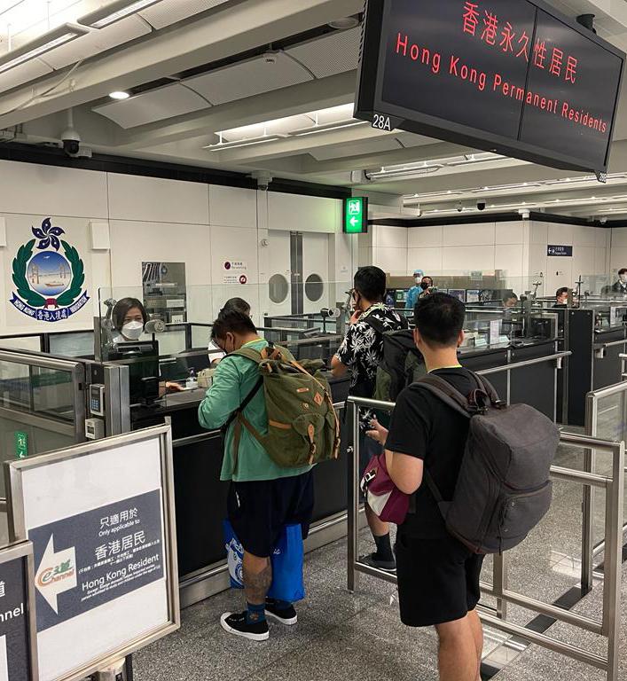 今日（八月二十六日）再有求助港人安全抵達香港國際機場。圖示入境處人員在專用櫃檯協助有關求助港人辦理出入境手續。