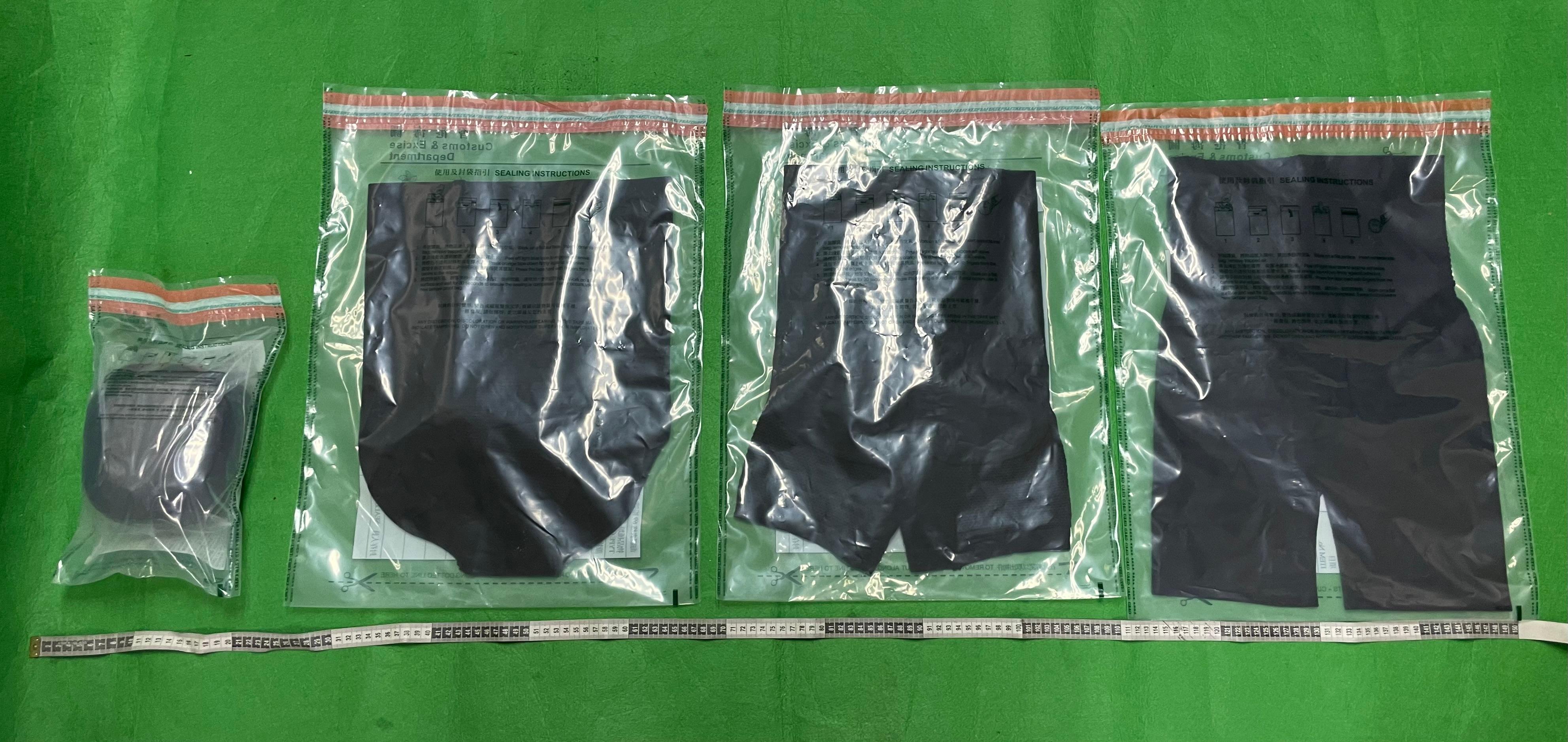 香港海關昨日（八月二十七日）在香港國際機場檢獲約一公斤懷疑可卡因，估計市值約八十四萬元。圖示檢獲的懷疑可卡因和用作收藏毒品的衣服。


