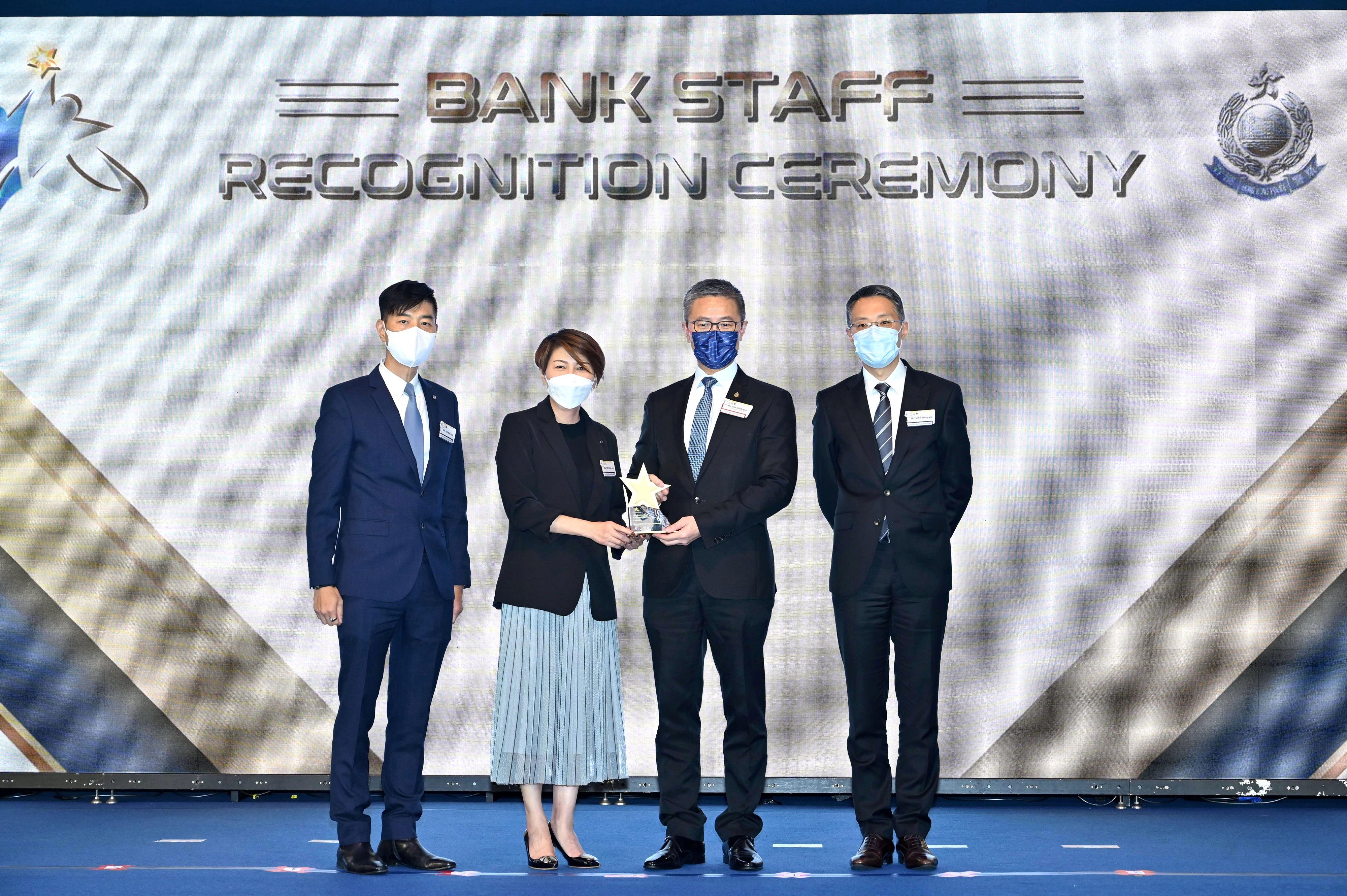 香港警務處今日（八月三十日）舉辦「傑出銀行員工嘉許典禮」。圖示警務處處長蕭澤頤（右二）頒獎予獲得最踴躍參與金獎的銀行代表。