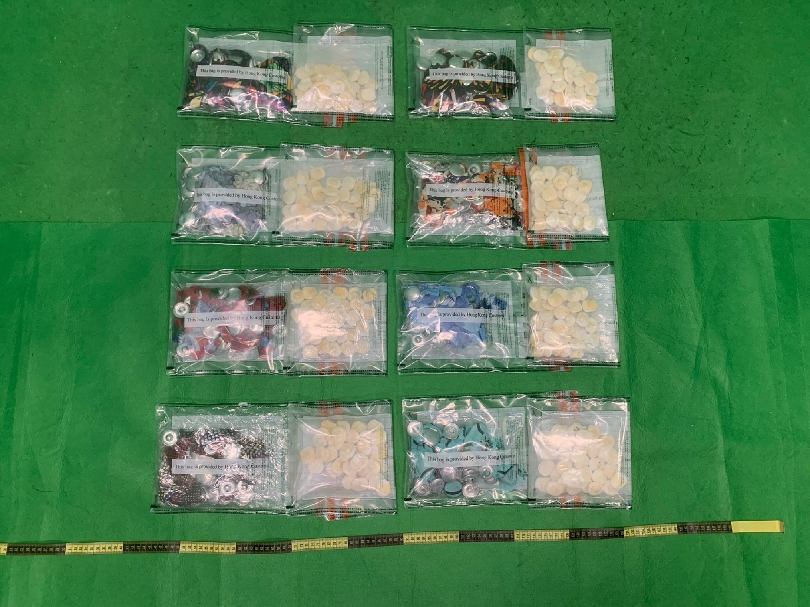 香港海關昨日（九月五日）在香港國際機場檢獲約一公斤懷疑可卡因，估計市值約八十八萬元。圖示檢獲的懷疑可卡因和用作收藏毒品的衣服鈕扣。