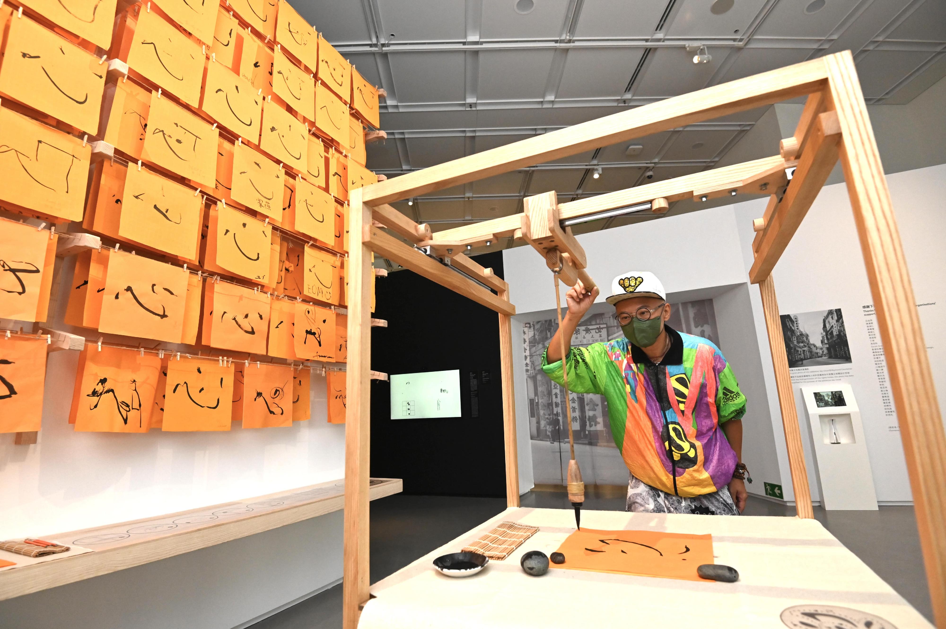 「字由人──漢字創意集」展覽明日（九月九日）起在香港藝術館舉行。圖示香港藝術家洪強與他的機械裝置作品《控制狂（v.2）》。