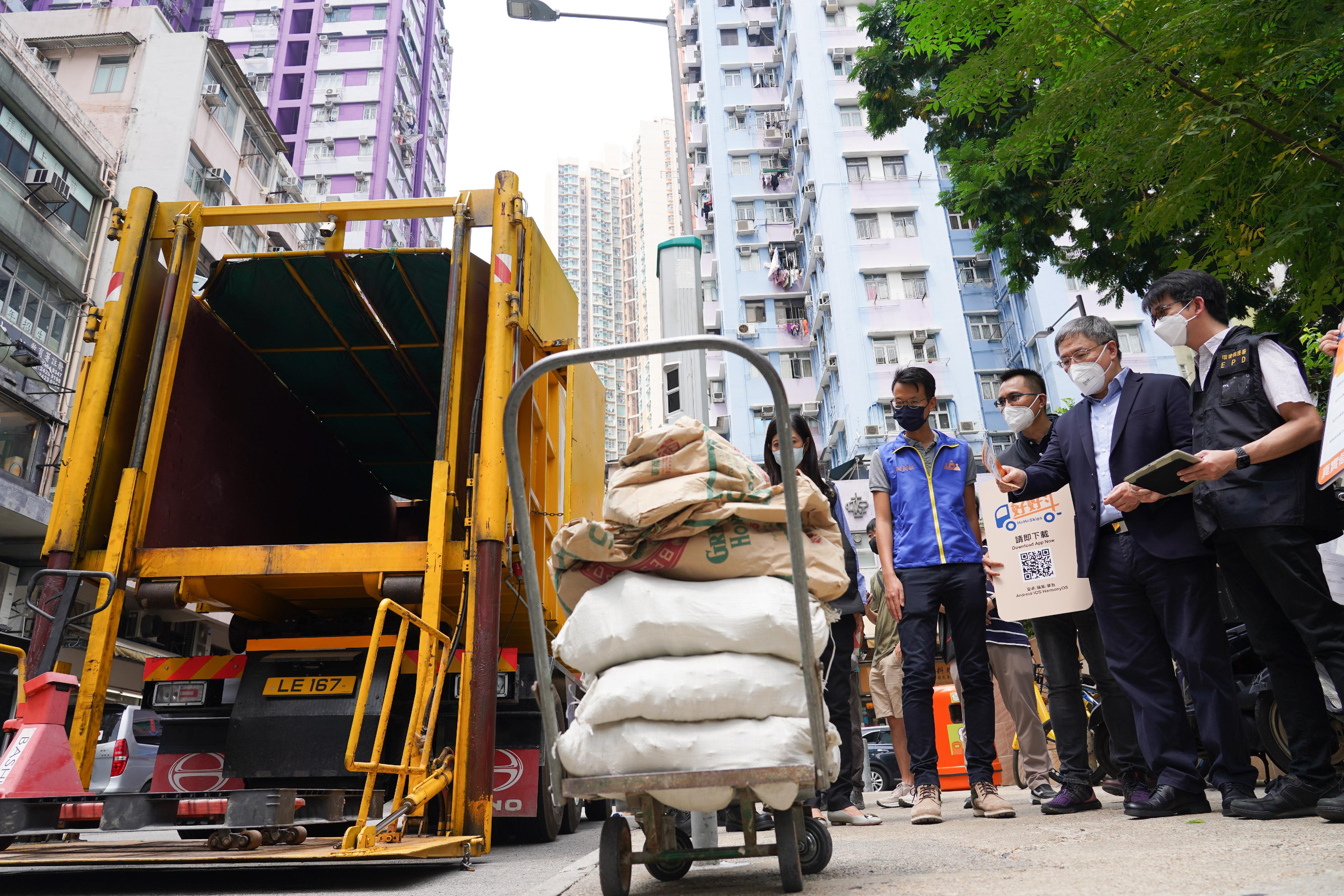 The Deputy Chief Secretary for Administration, Mr Cheuk Wing-hing (second right), today (September 16) views the operation of the HoHoSkips booking service for construction waste collection in Kwong Fai Circuit, Kwai Chung.