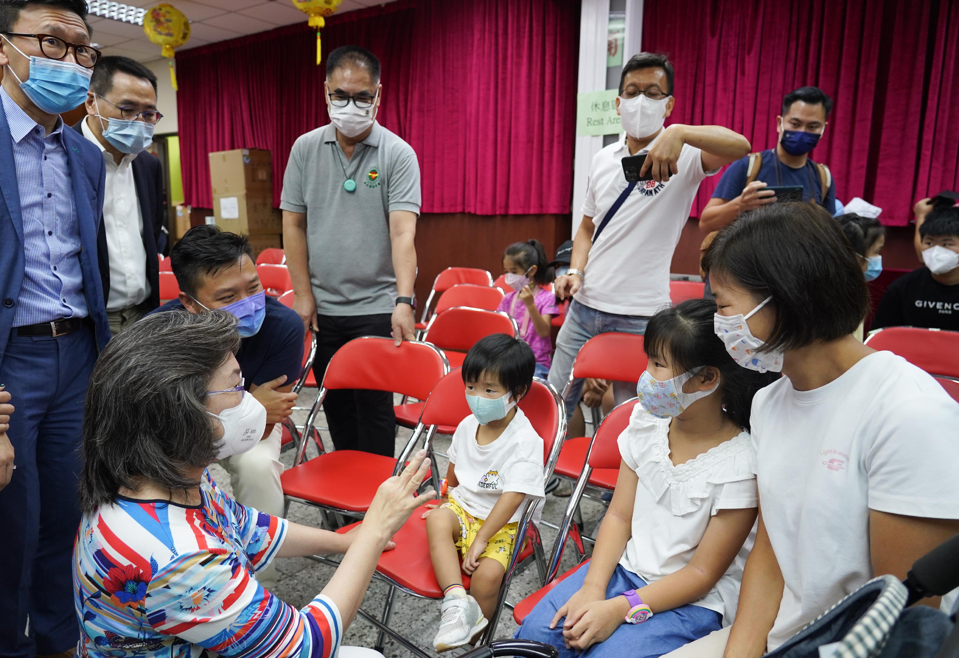 The Secretary for the Civil Service, Mrs Ingrid Yeung, attended a COVID-19 vaccination event in Sham Shui Po today (September 17) and appealed to members of the public to take action to receive a suitable number of vaccine doses on time for self-protection. Photo shows Mrs Yeung (front row, first left) chatting with children who just received their COVID-19 vaccine.