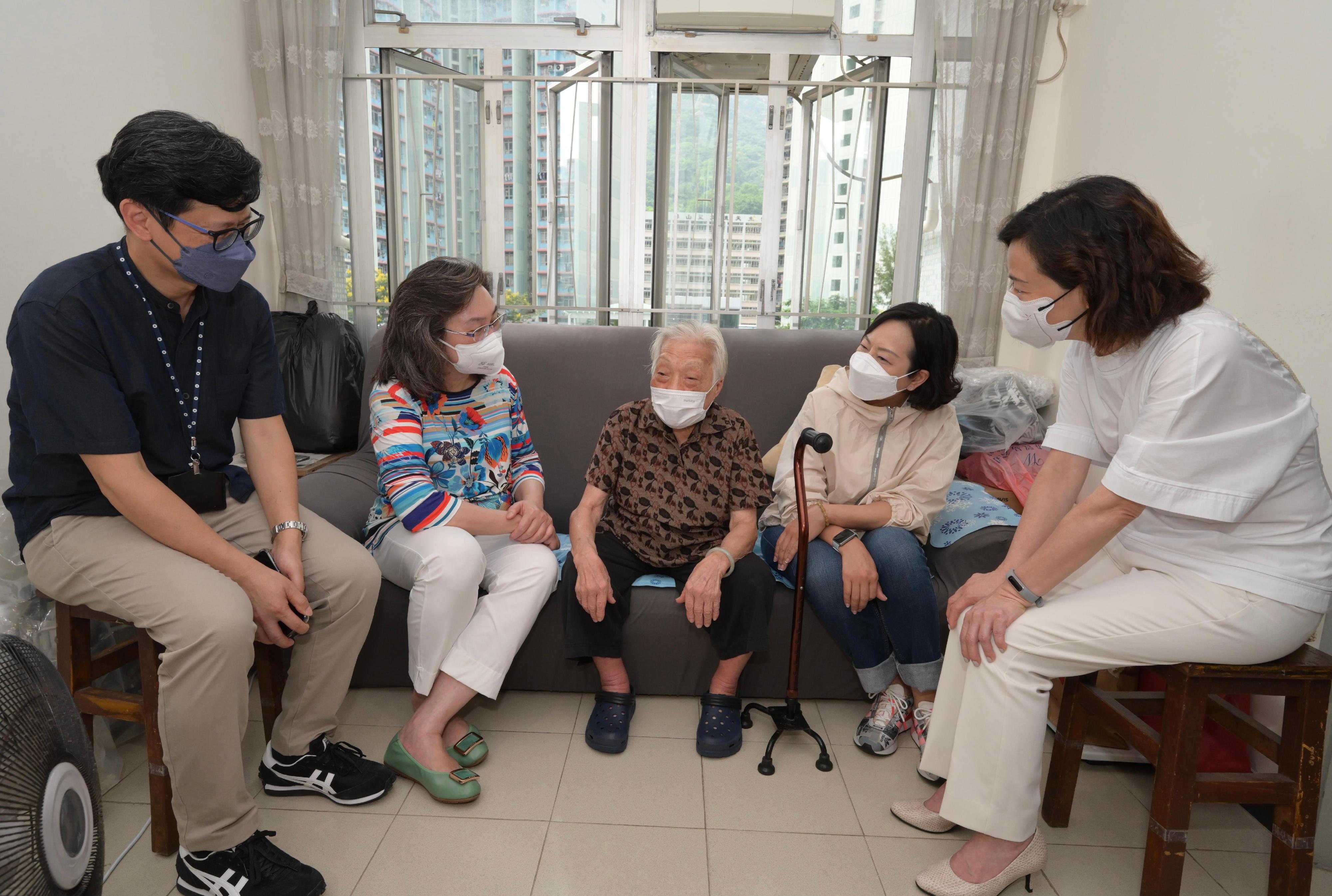 To further encourage elderly persons to receive COVID-19 vaccination for self-protection, various government departments worked with a district group and the property management sector to roll out at Tsz Hong and Tsz Man Estates in Wong Tai Sin a pilot scheme to visit elderly persons in order to encourage them to receive COVID-19 vaccination. For two consecutive days starting from today (September 17), they will pay door-to-door visits to households with elderly persons aged 70 or above at the two estates. Photo shows the Secretary for the Civil Service, Mrs Ingrid Yeung (second left), and the Secretary for Home and Youth Affairs, Miss Alice Mak (second right), visiting an 89-year-old elderly (centre) living in Tsz Man Estate to encourage her to receive COVID-19 vaccination. Looking on are the Director of Home Affairs, Mrs Alice Cheung (first right), and the Deputy Director of Housing (Estate Management), Mr Ricky Yeung (first left).