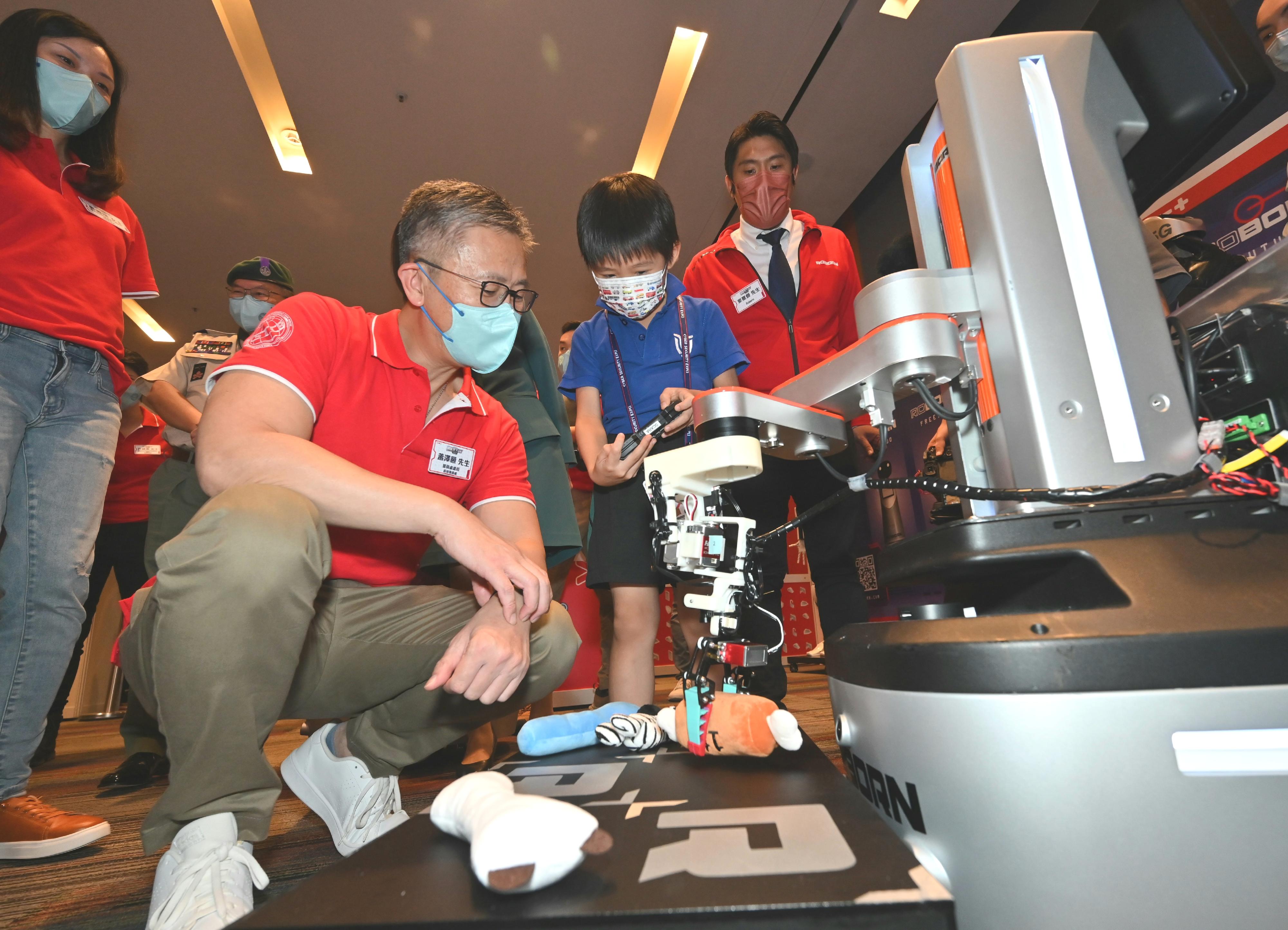 The Cyber Security Expo 2022 kicks off today (September 17). Photo shows the Commissioner of the Police, Mr Siu Chak-yee (second left) watching a robot demonstration by a student.
