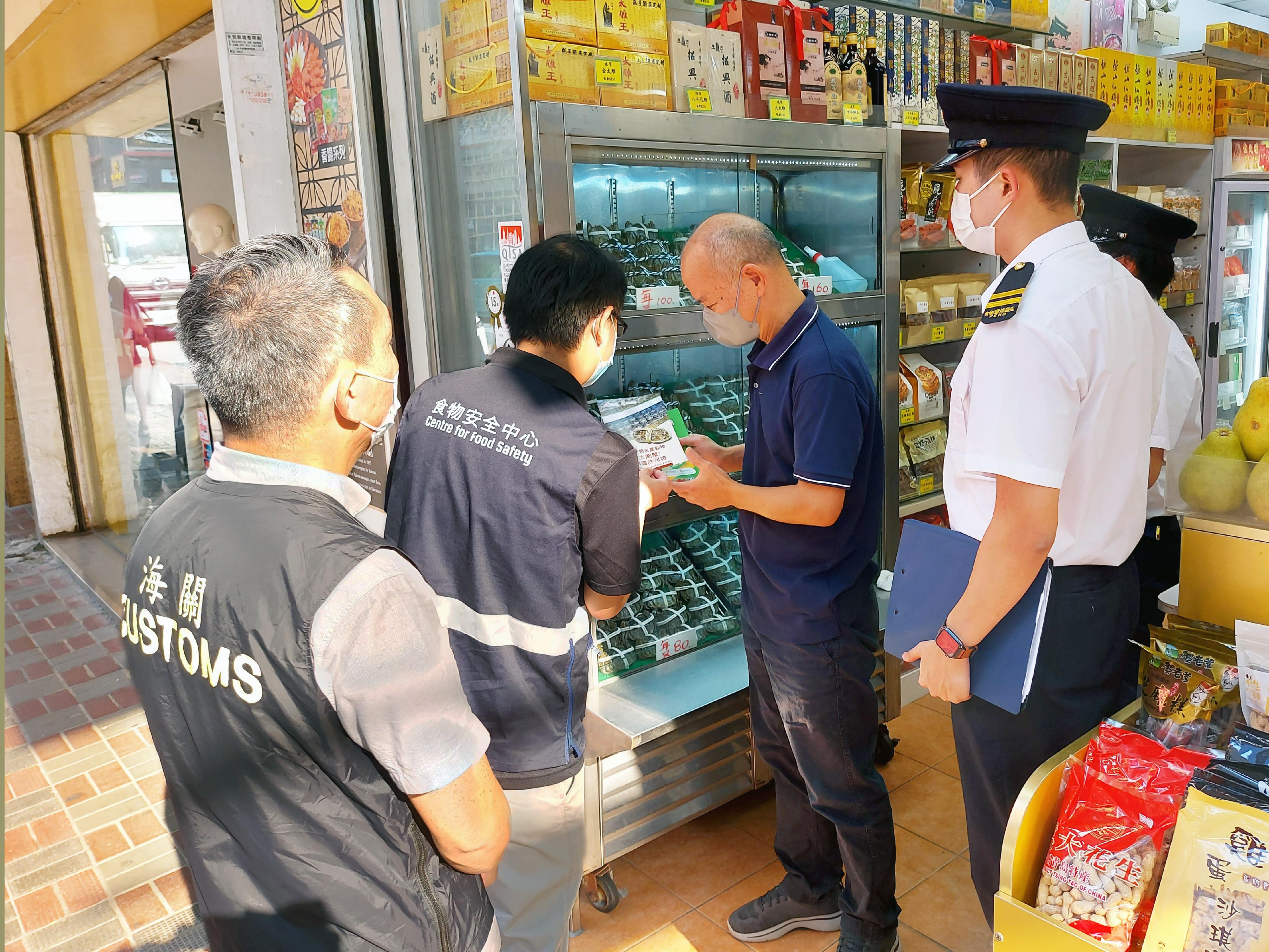Hong Kong Customs and the Centre for Food Safety and the Environmental Hygiene Branch of the Food and Environmental Hygiene Department (FEHD) have been carrying out joint enforcement operations since last Thursday (September 15) to inspect hairy crab retail outlets in various districts, with the aim of protecting consumer rights and upholding food safety by ensuring hairy crabs on sale in the market comply with relevant stipulations and requirements under the laws. Photo shows Customs officers and FEHD officers inspecting a retail shop selling hairy crabs and distributing relevant promotional leaflets.