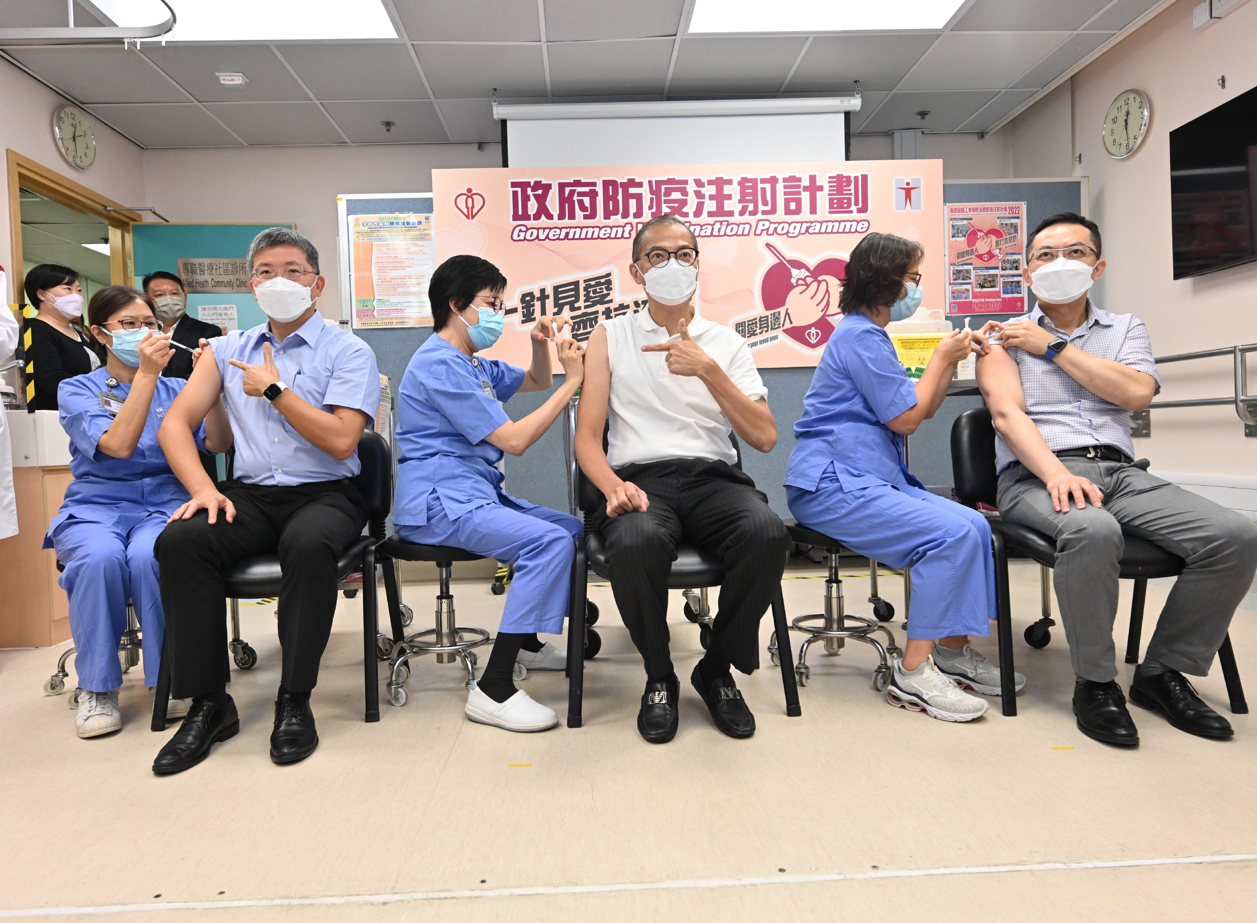 The Secretary for Health, Professor Lo Chung-mau (third right); the Permanent Secretary for Health, Mr Thomas Chan (second left); and the Director of Health, Dr Ronald Lam (first right), receive both the seasonal influenza vaccination and Sinovac COVID-19 vaccine at the Sai Wan Ho General Out-patient Clinic today (September 22).