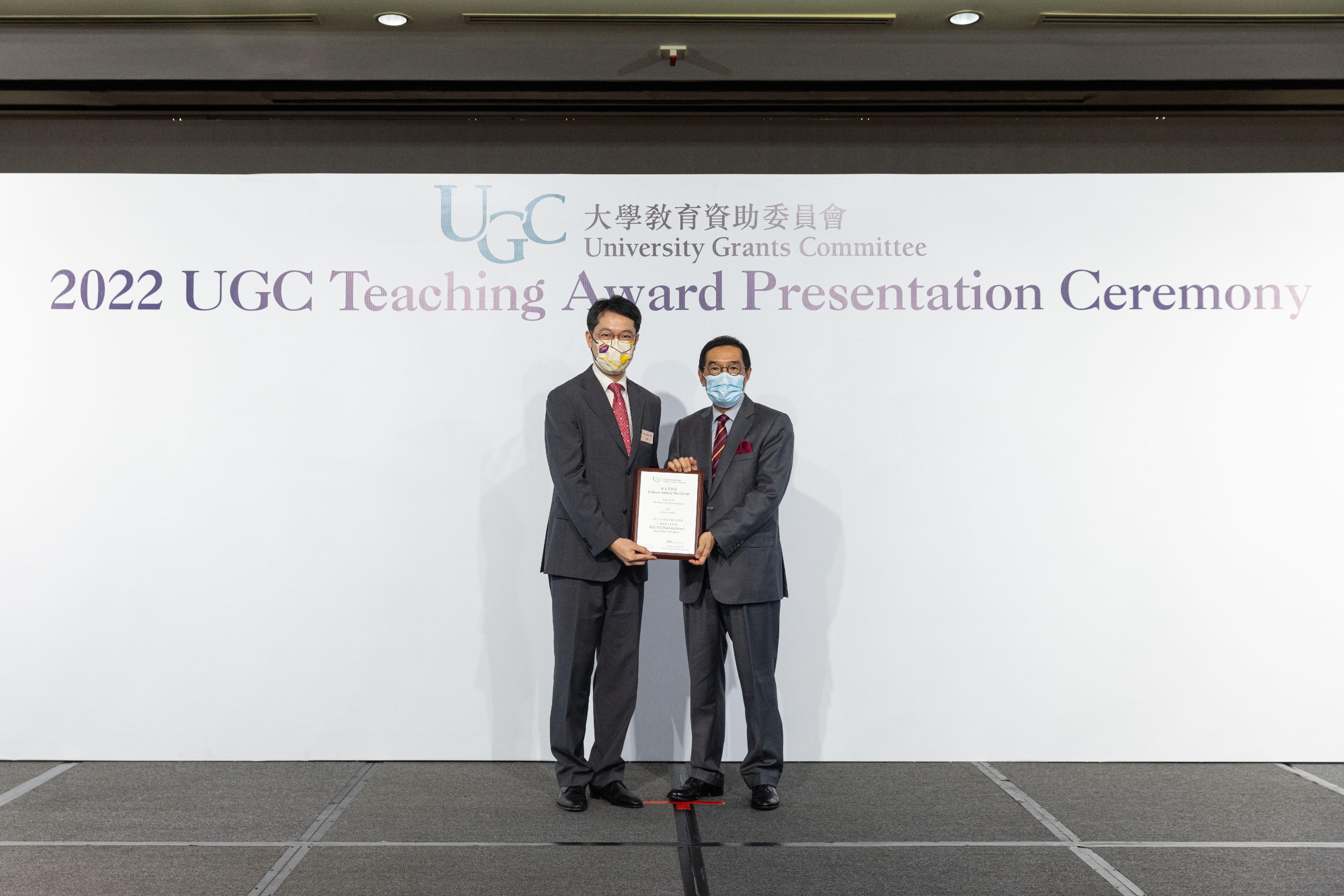 The Chairman of the University Grants Committee (UGC), Mr Carlson Tong (right), presents the 2022 UGC Teaching Award for General Faculty Members to Professor Anthony So Man-cho.