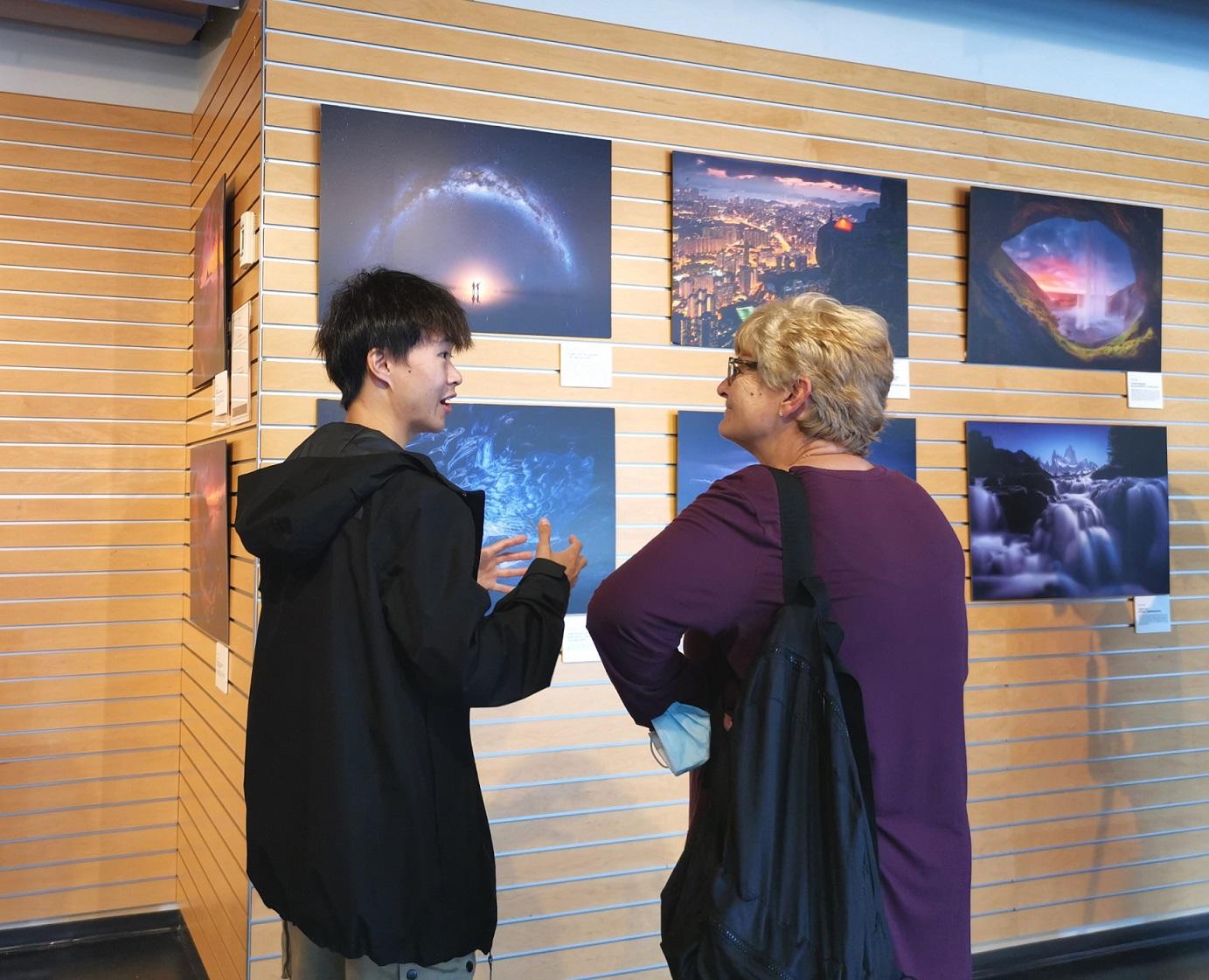 香港攝影師袁斯樂（左）於九月六日（溫哥華時間）在溫哥華卑詩大學Robson Square舉行的「大地之旅」攝影展的「與攝影師交流」活動上與一位攝影師交流。