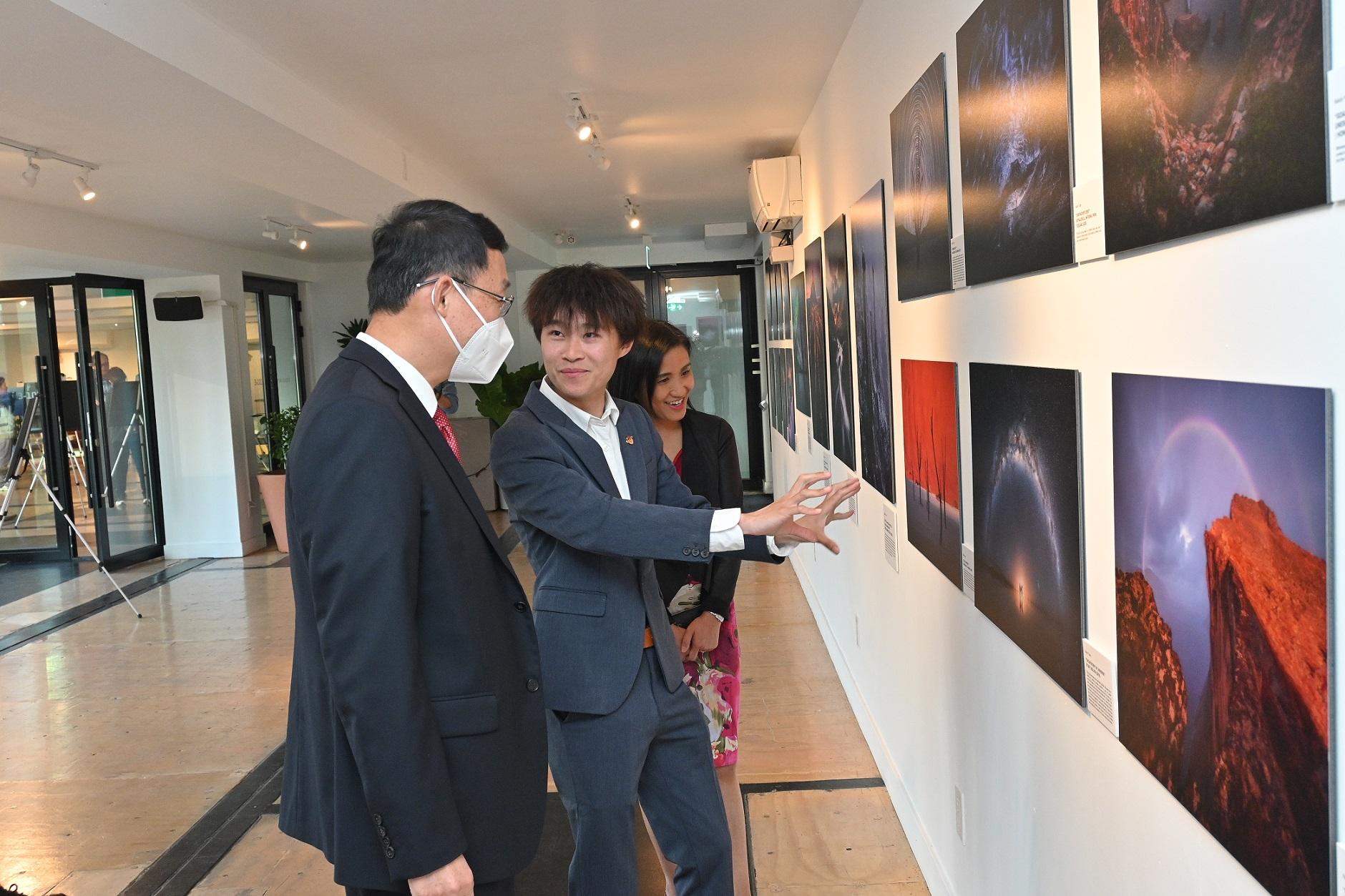 The Director of the Hong Kong Economic and Trade Office (Toronto), Ms Emily Mo (first right) and the Consul General of the People's Republic of China in Toronto, Mr Han Tao (first left), listen to the briefing by Hong Kong photographer Kelvin Yuen (centre) during a tour to the photos displayed at the "A Landscape Journey" photography exhibition yesterday (October 4, Toronto time).