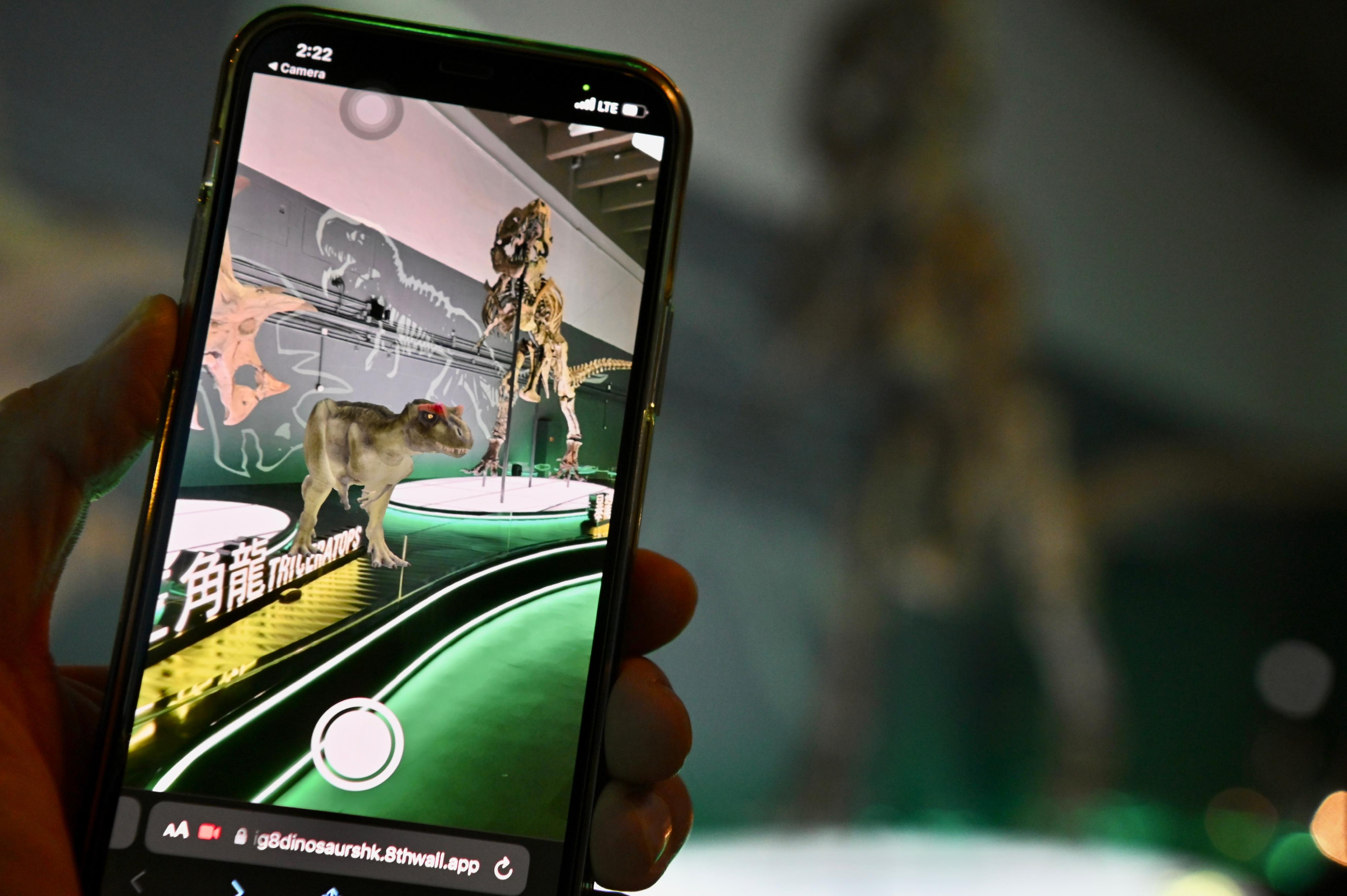 香港科學館的免費大型恐龍展覽「香港賽馬會呈獻系列：八大‧尋龍記」，自七月開展以來深受市民歡迎。圖示參觀者利用智能手機，以擴增實境技術與恐龍互動。