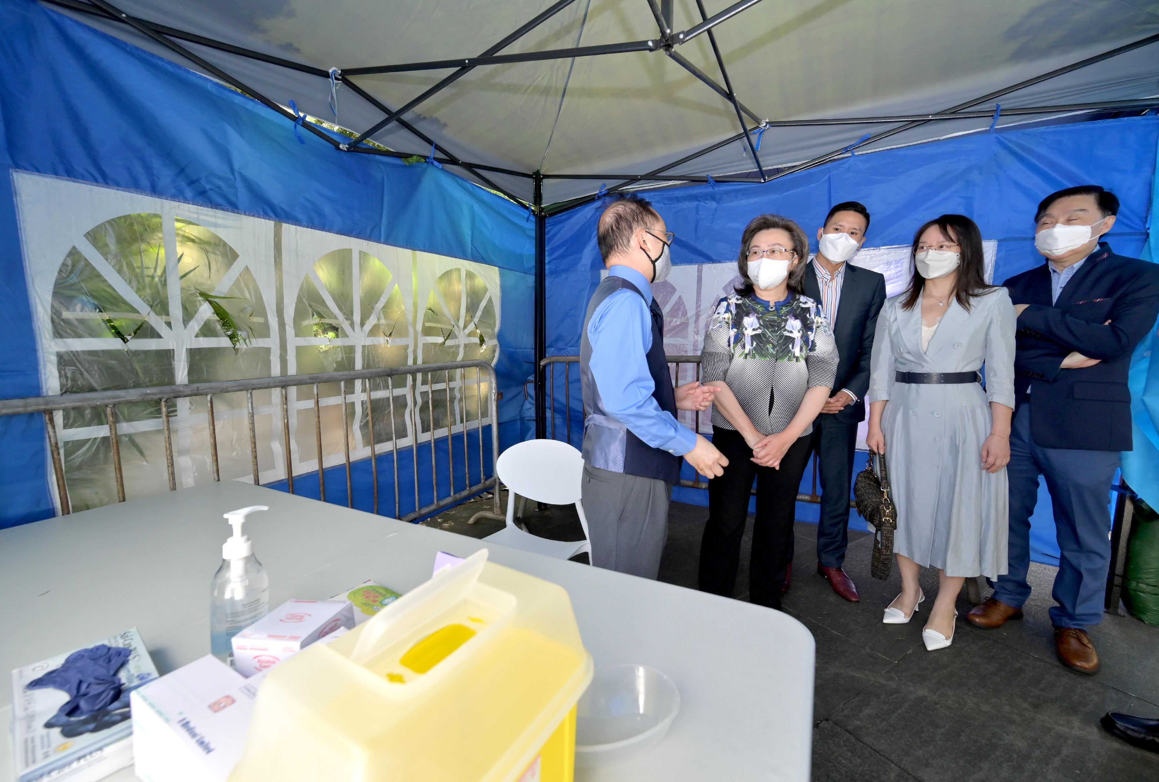 The Secretary for the Civil Service, Mrs Ingrid Yeung, visited the Wong Tai Sin Temple Square Community Vaccination Station (CVS) this morning (October 12) to view its first-day operation. Photo shows Mrs Yeung (second left) being briefed by the person-in-charge of the medical partner of the CVS, Dr Ares Leung (first left), on the facilities of the CVS. Looking on is the District Officer (Wong Tai Sin), Mr Steve Wong (centre).
