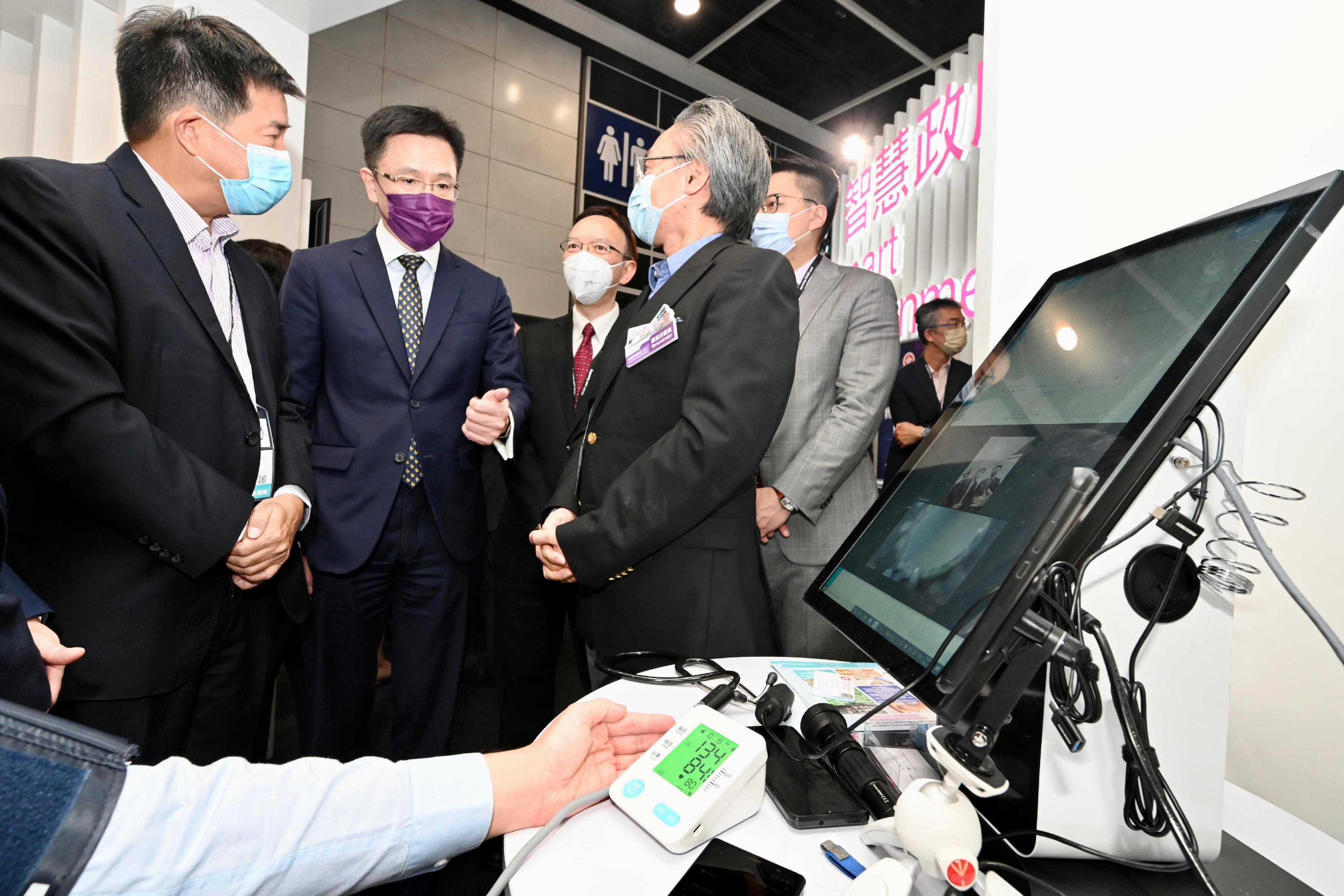 The Secretary for Innovation, Technology and Industry, Professor Sun Dong (second left), visits the Smart Government Pavilion at the International ICT Expo today (October 13) and is briefed on the Telehealth Booth of Heung Yee Kuk.