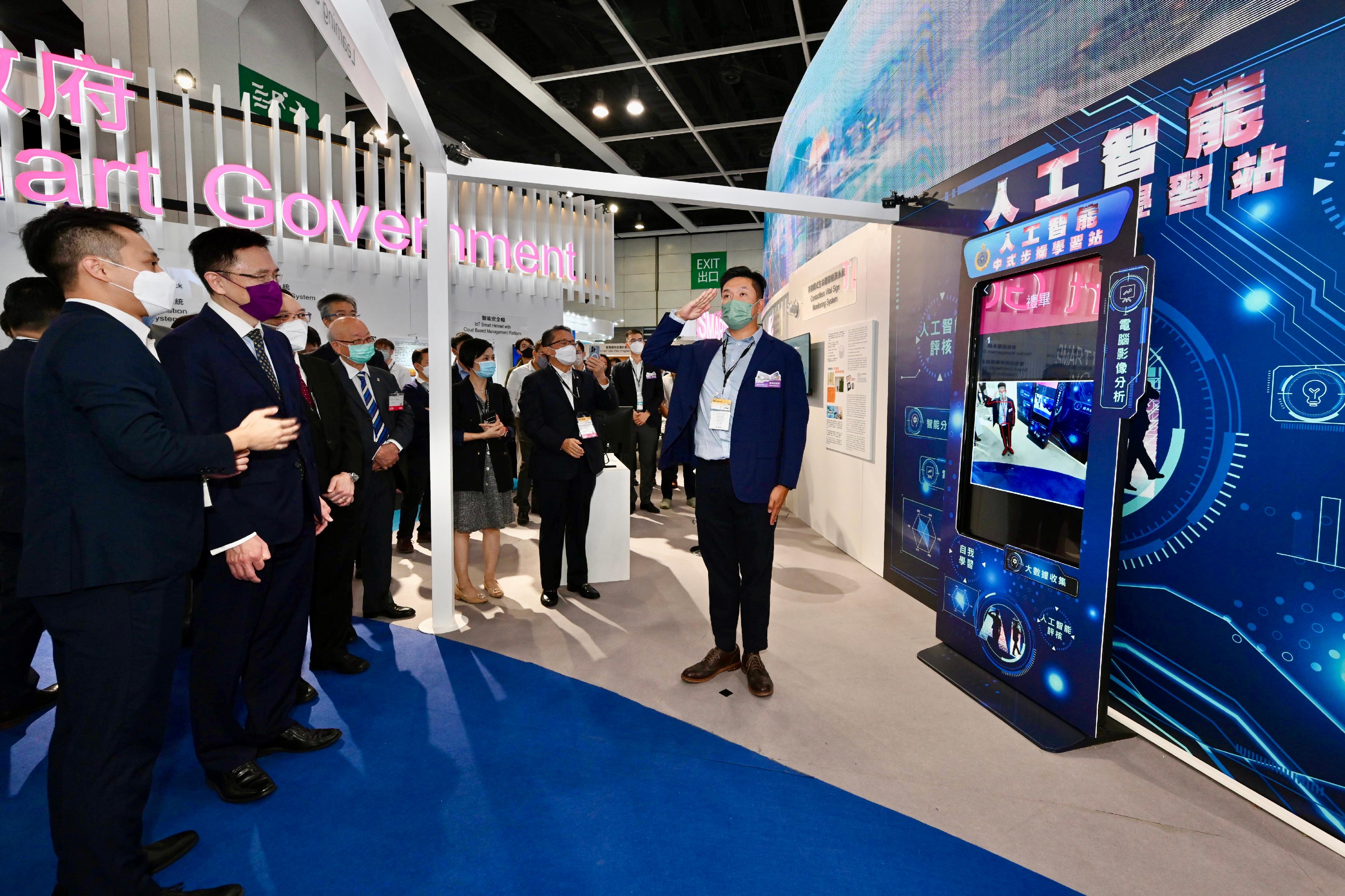 The Secretary for Innovation, Technology and Industry, Professor Sun Dong (second left), visits the Smart Government Pavilion at the International ICT Expo today (October 13) and is briefed on the artificial intelligence Chinese-style foot drill learning station.