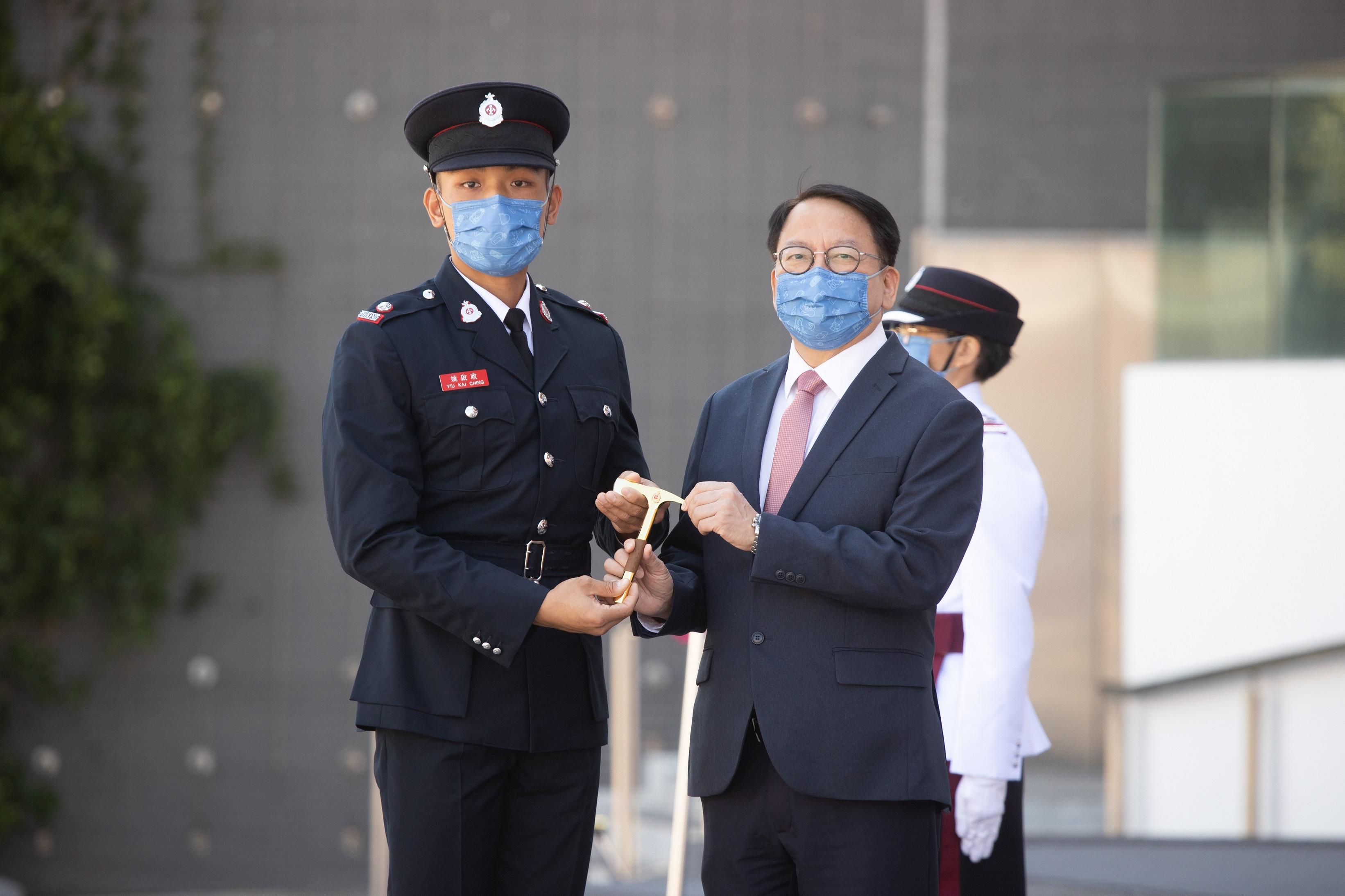 The Chief Secretary for Administration, Mr Chan Kwok-ki, reviewed the Fire Services passing-out parade at the Fire and Ambulance Services Academy today (October 21). Photo shows Mr Chan (right) presenting the Best Recruit Station Officer award to a graduate.