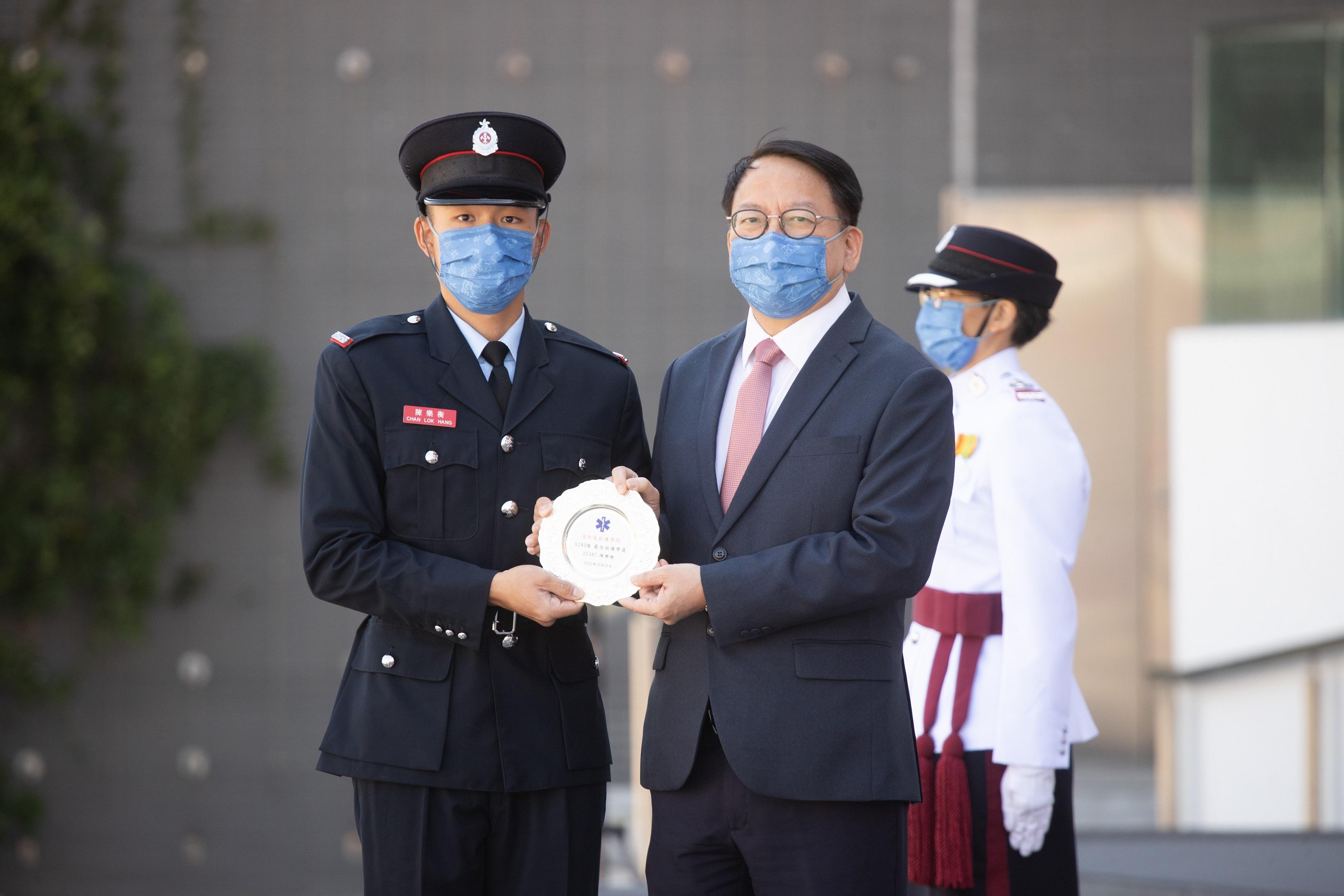 The Chief Secretary for Administration, Mr Chan Kwok-ki, reviewed the Fire Services passing-out parade at the Fire and Ambulance Services Academy today (October 21). Photo shows Mr Chan (right) presenting the Best Recruit Ambulanceman award to a graduate.