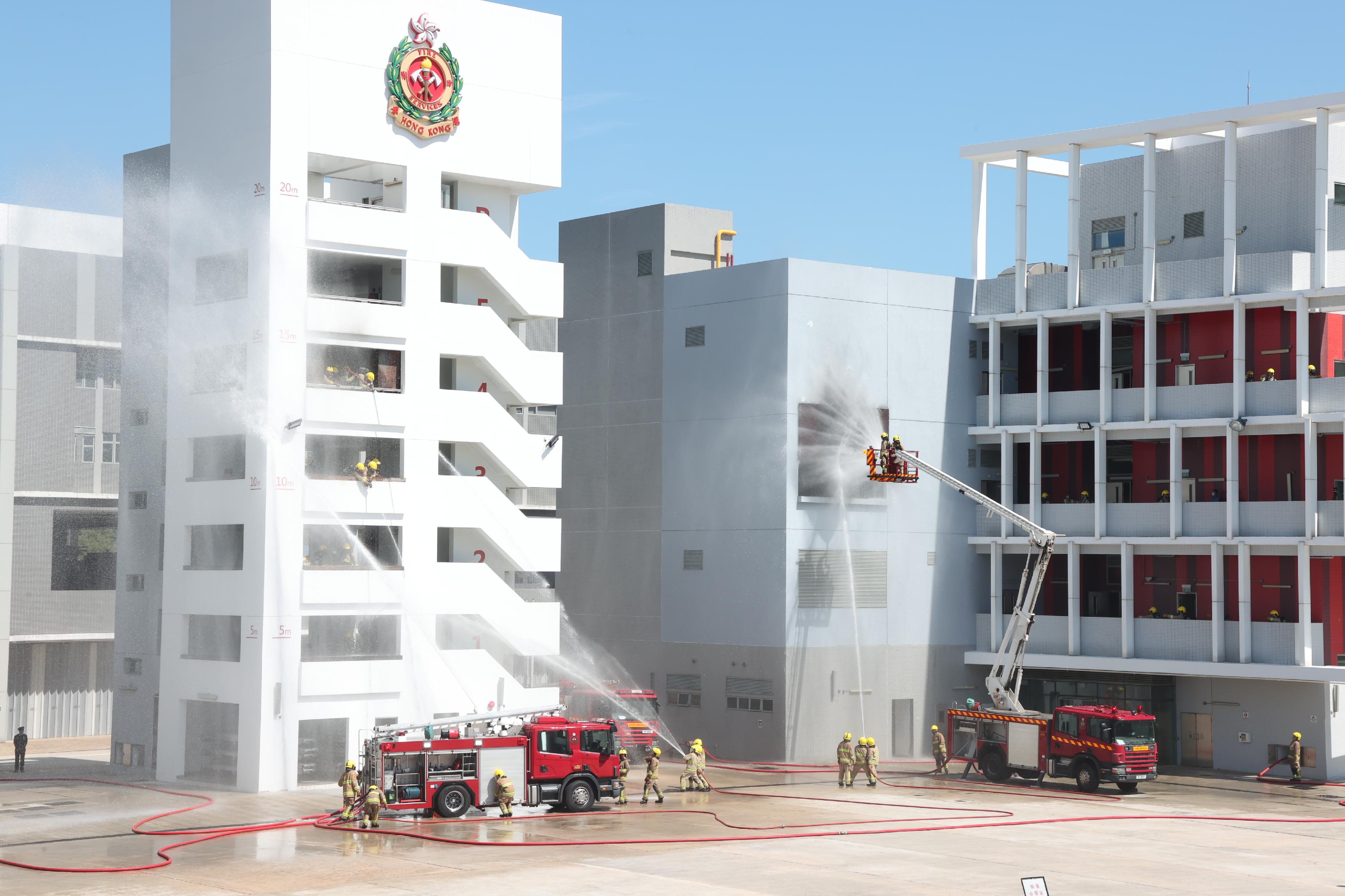 The Chief Secretary for Administration, Mr Chan Kwok-ki, reviewed the Fire Services passing-out parade at the Fire and Ambulance Services Academy today (October 21). Photo shows graduates demonstrating firefighting techniques.