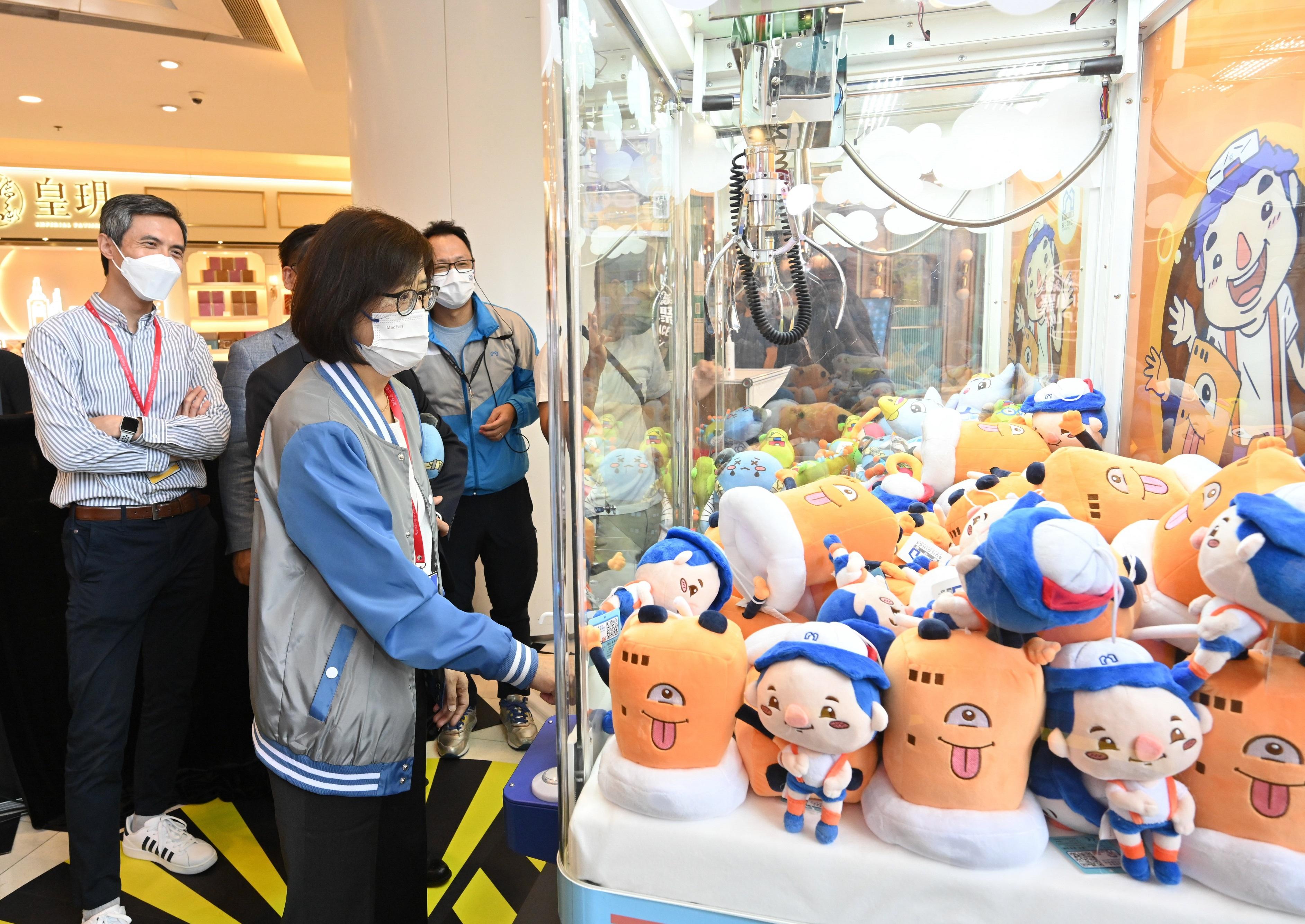 The Director of Buildings, Ms Clarice Yu, tries one of the booth games at the Building Safety Carnival after the opening ceremony of Building Safety Week 2022 today (October 22).