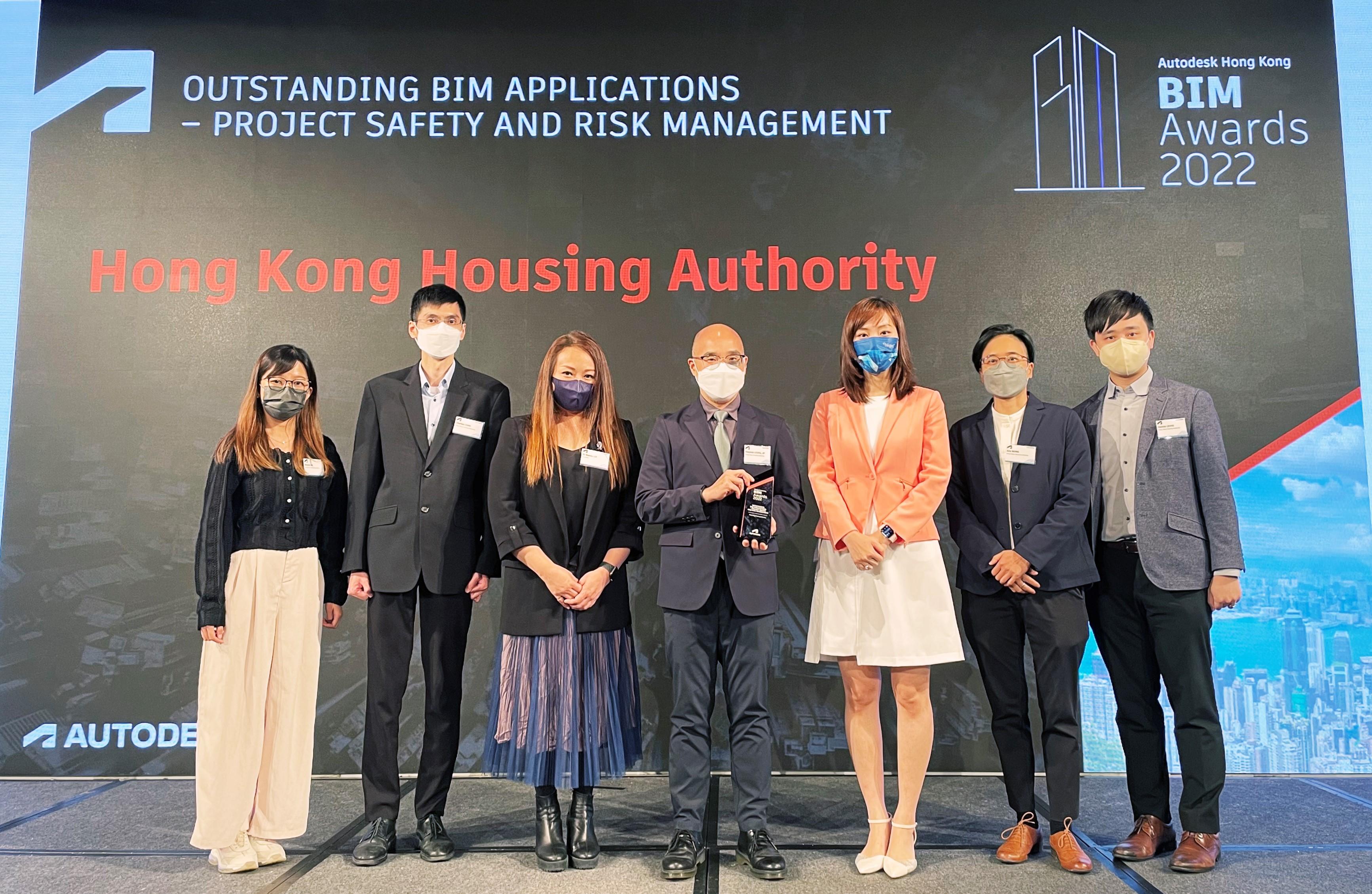 香港房屋委員會（房委會）在歐特克香港建築信息模擬設計大獎2022獲頒一個項目獎，獲獎項目為「應用建築信息模擬技術於施工安全規劃及風險管理」。圖示房屋署副署長（發展及建築）梁健文（中）與房委會獲獎項目團隊在十月二十六日舉行的頒獎禮上合照。