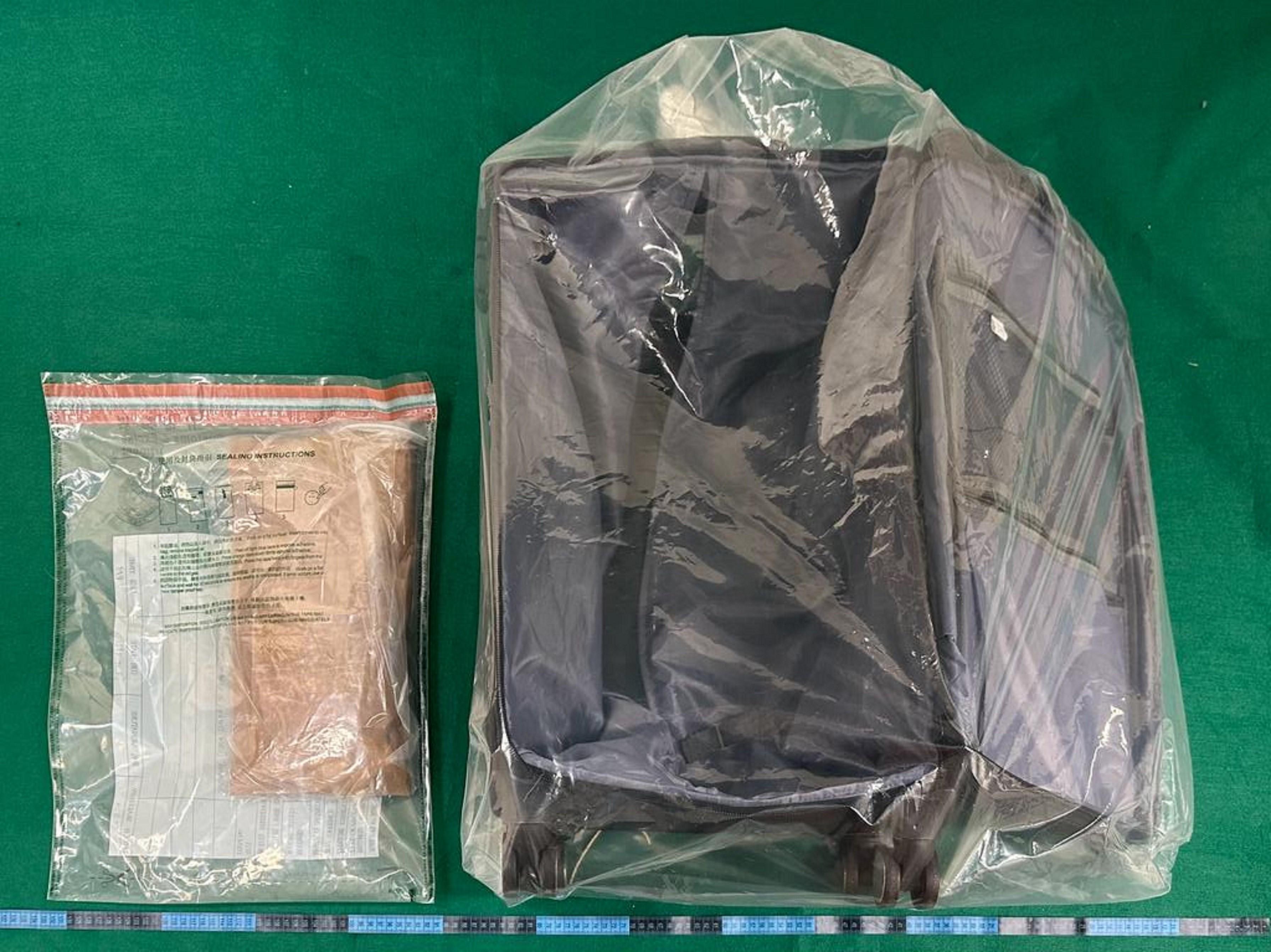 香港海关昨日（十月二十八日）在香港国际机场检获约一公斤怀疑可卡因，估计市值约九十万元。图示检获的怀疑可卡因和用作收藏毒品的寄舱行李箱。
