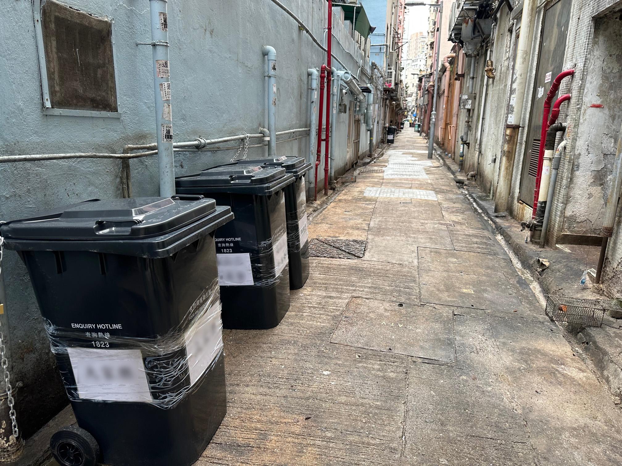 The Food and Environmental Hygiene Department today (November 7) begins a trial scheme in various districts to allow licensed food premises to place large-size waste containers in their connected rear lanes under specific conditions, for temporary storage of waste until collection by the cleaning workers hired by the food premises. Photo shows large size waste containers in a rear lane in Kowloon City District.

