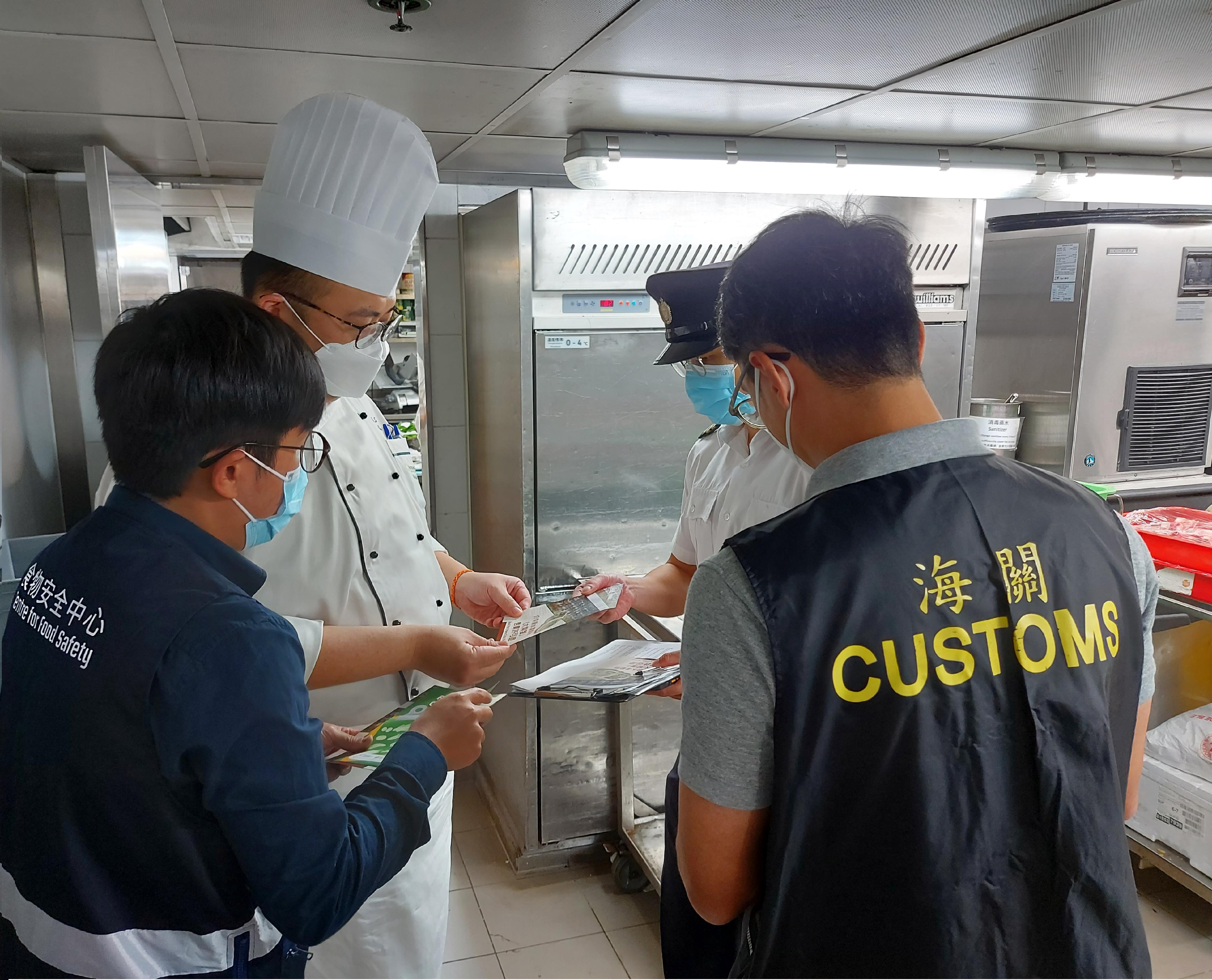 To safeguard food safety, the Food and Environmental Hygiene Department (FEHD) and Hong Kong Customs have launched a series of blitz operations from October 28 to inspect selling points of hairy crabs in various districts and combat the illegal sale of hairy crabs, with a view to ensuring that hairy crabs on sale in the market comply with relevant requirements under the laws. Photo shows officers of the FEHD and Customs distributing promotional leaflets to the operator of a food premises.