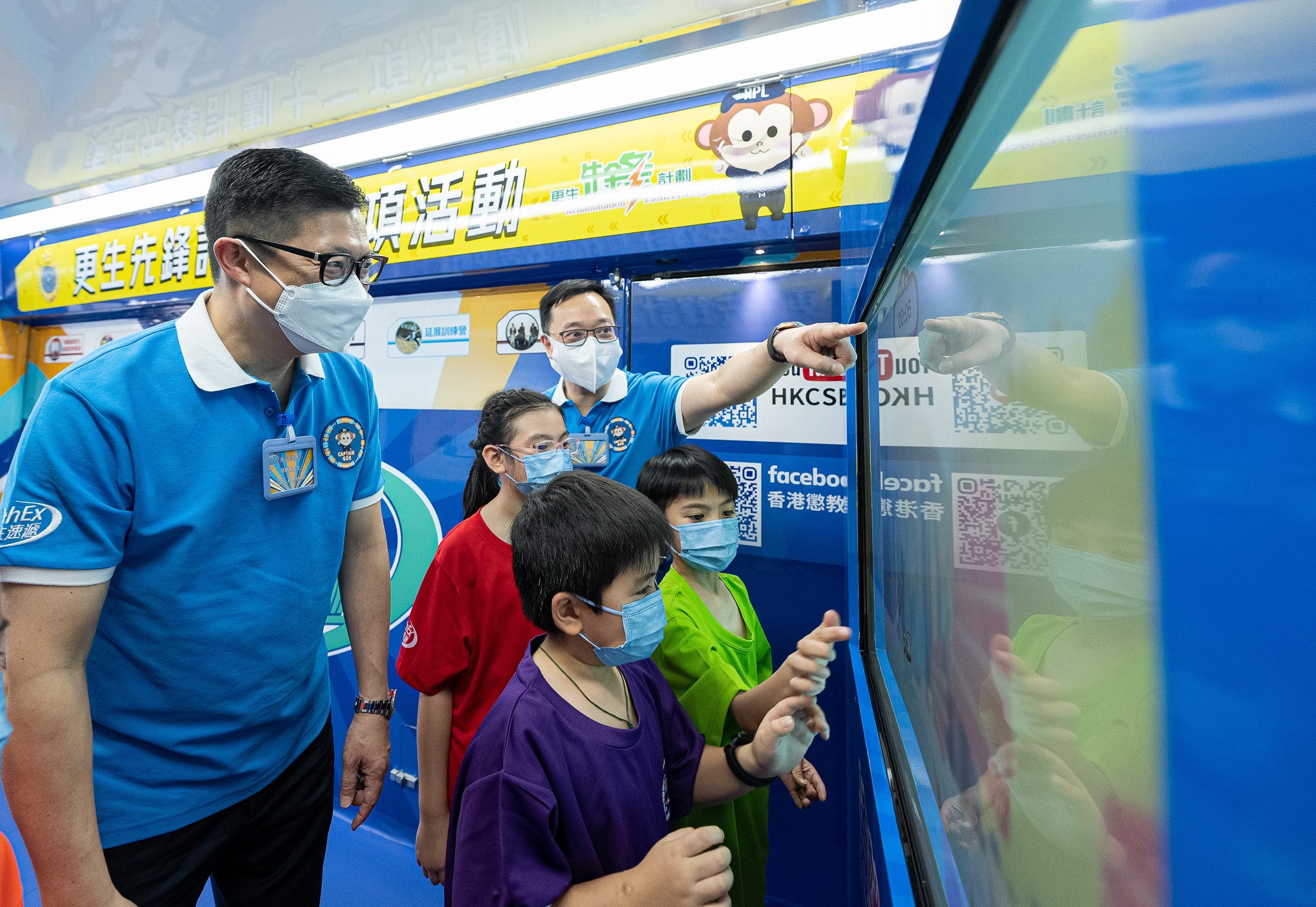 The Correctional Services Department held the kick-off ceremony of its brand-new community education activity "Rehabilitation Express" today (November 11). Photo shows the Secretary for Security, Mr Tang Ping-keung (first left), and the Commissioner of Correctional Services, Mr Wong Kwok-hing (back row, first right), playing an electronic game with students on board the promotion vehicle.

